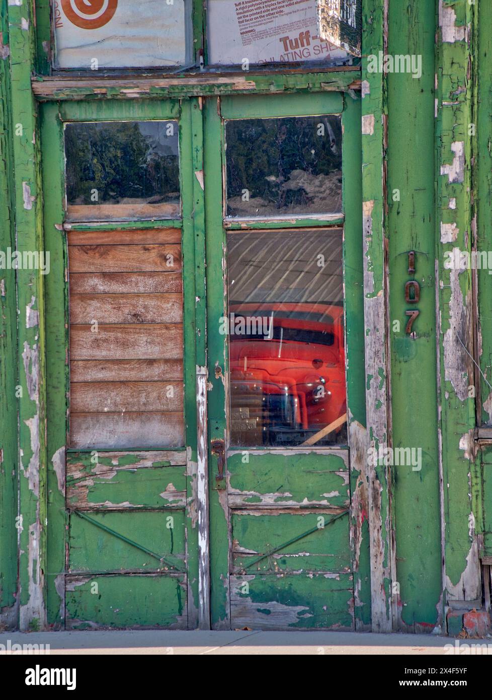 Reflet d'un vieux camion rouge dans la fenêtre d'une ancienne façade de magasin dans une ville dans la Palouse. Banque D'Images