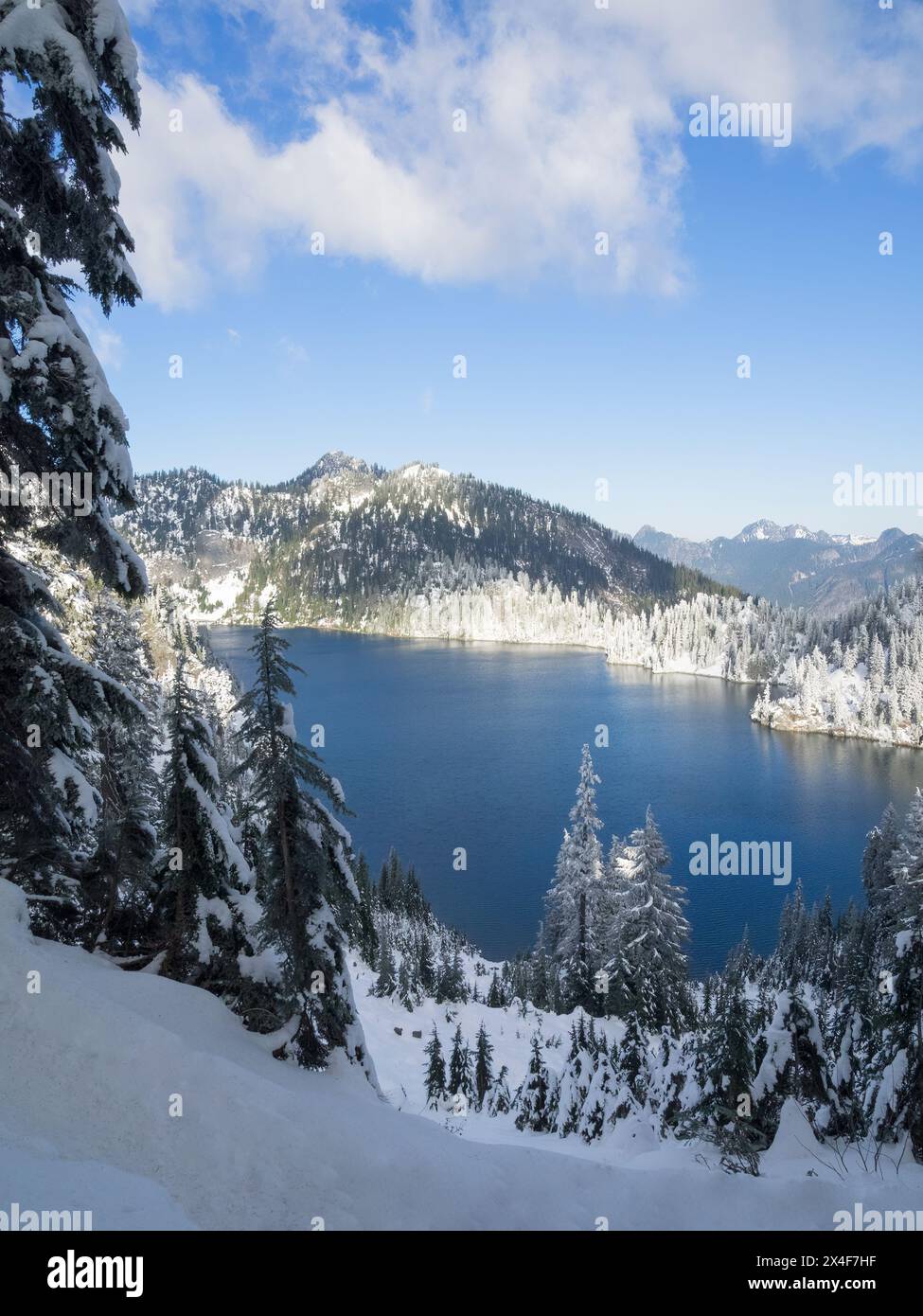 États-Unis, État de Washington, Alpine Lakes Wilderness. Vue sur le lac des neiges et les montagnes avec des sapins couverts de neige Banque D'Images