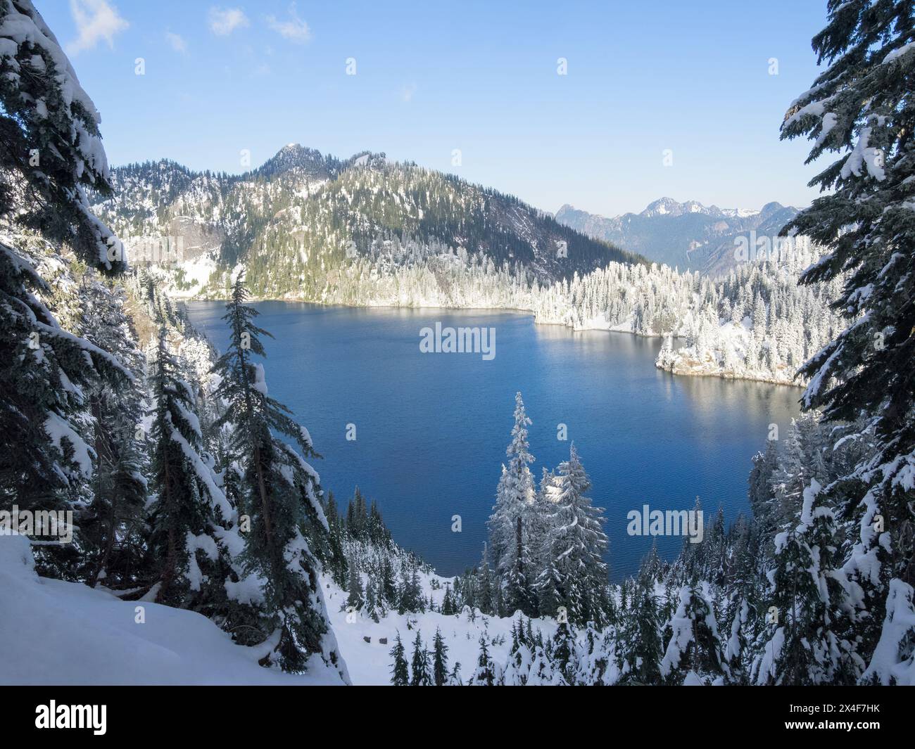 États-Unis, État de Washington, Alpine Lakes Wilderness. Vue sur le lac des neiges et les montagnes avec des sapins couverts de neige Banque D'Images