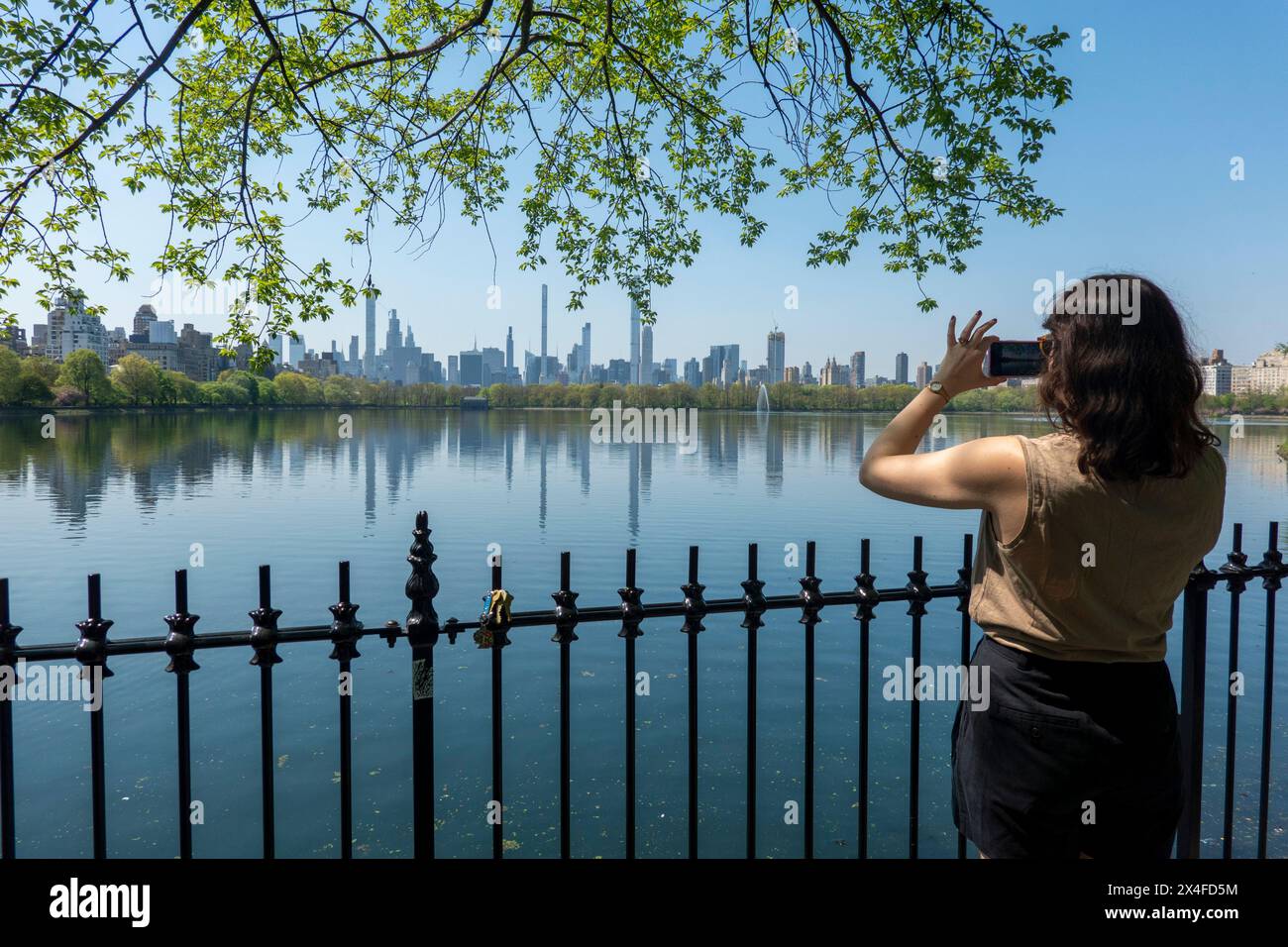Femme photographiant la vue du réservoir de Central Park, New York City, USA Banque D'Images