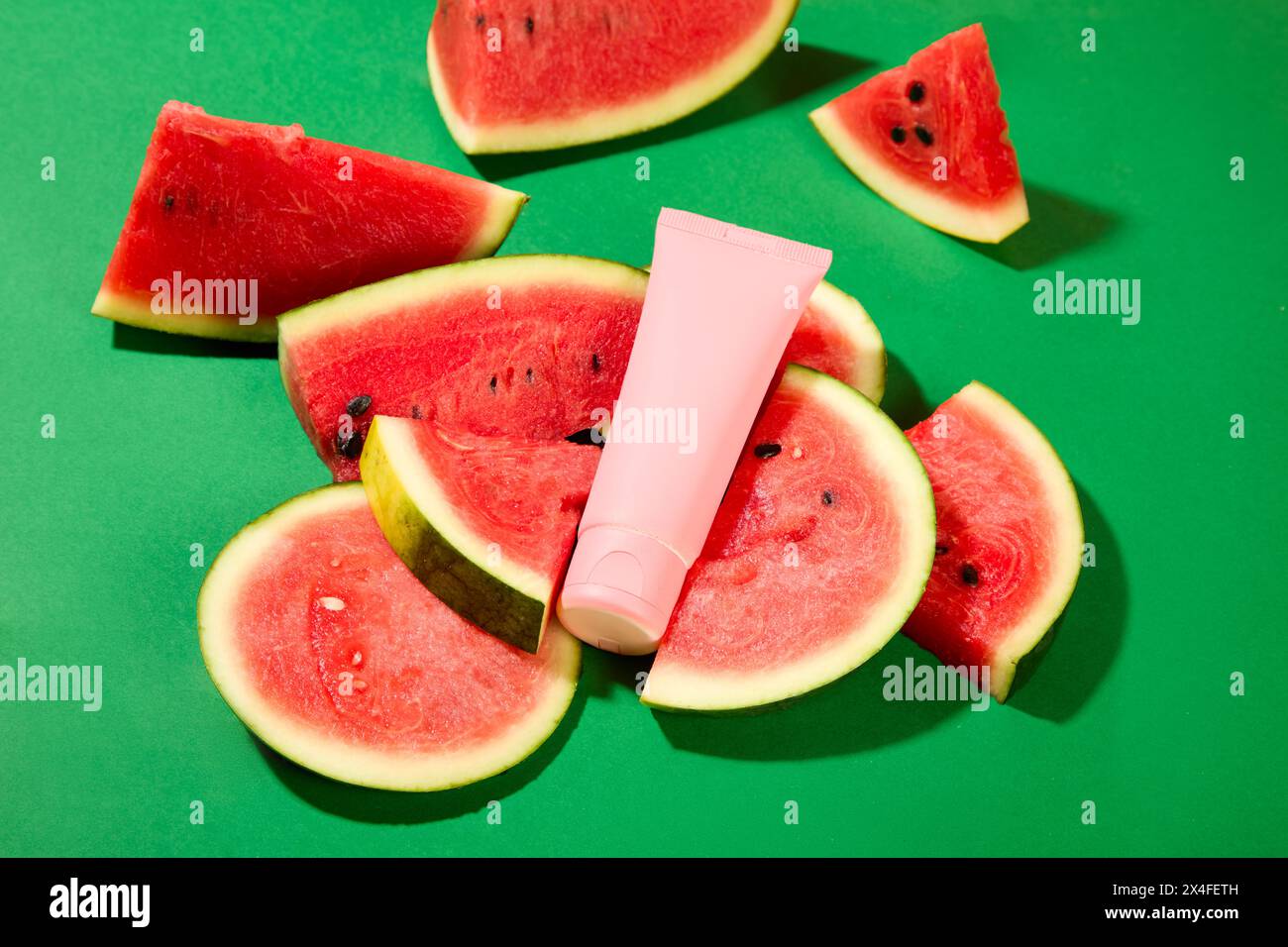 Scène maquette pour la publicité cosmétique. Bouteille cosmétique et tranches de pastèque sur fond vert. La pastèque est chargée de vitamine C, qui instantanément Banque D'Images