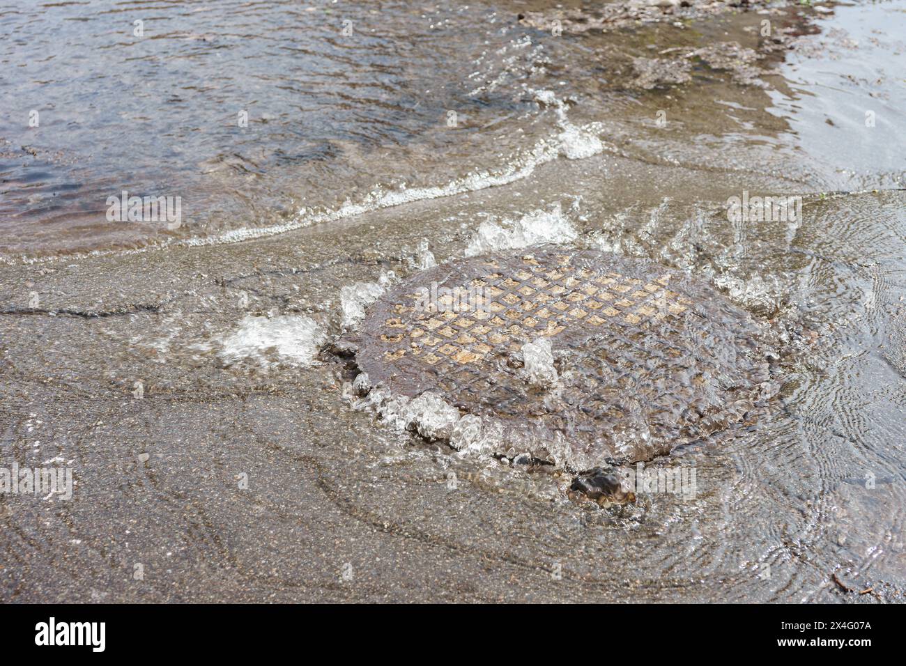 Fontaine d'eau déverse de la trappe d'égout, système d'égout percé. Accident d'approvisionnement en eau, eaux usées. Écoulements d'eau, fontaine de drainage sur la route Banque D'Images