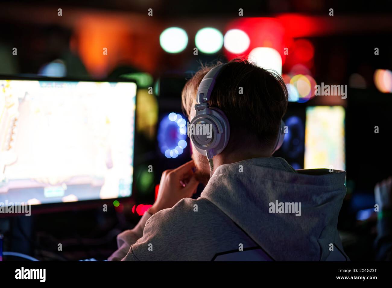Adolescent jouant à un jeu vidéo sur un ordinateur de bureau PC de l'arrière. Photo de haute qualité Banque D'Images