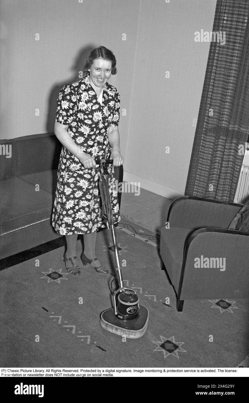 Journée de nettoyage dans les années 1940 Une femme au foyer fait la démonstration du dernier appareil de nettoyage pour rafraîchir les tapis. 1940. Kristoffersson ref 54-11 Banque D'Images
