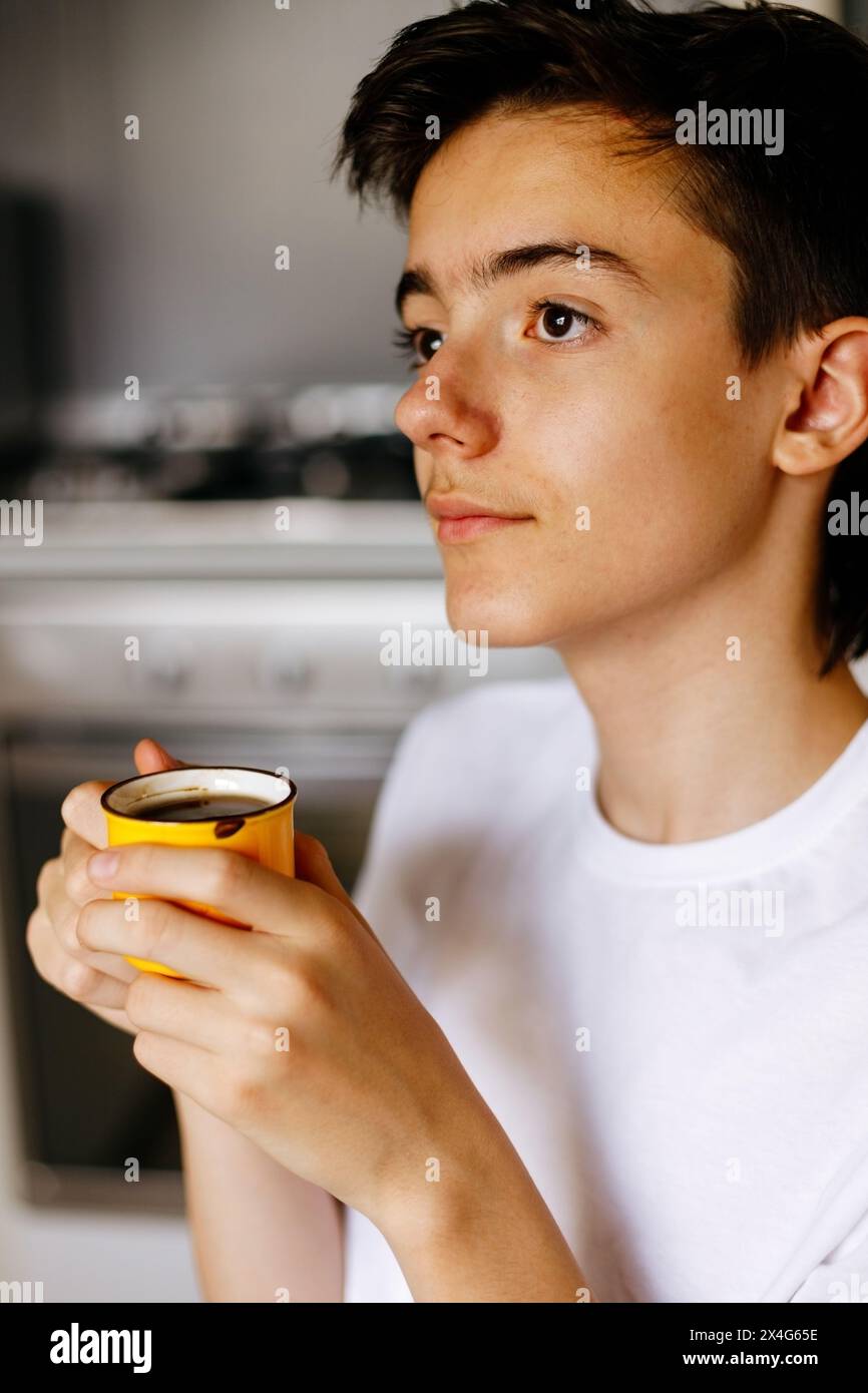 Adolescent avec tasse de café à la maison. Banque D'Images