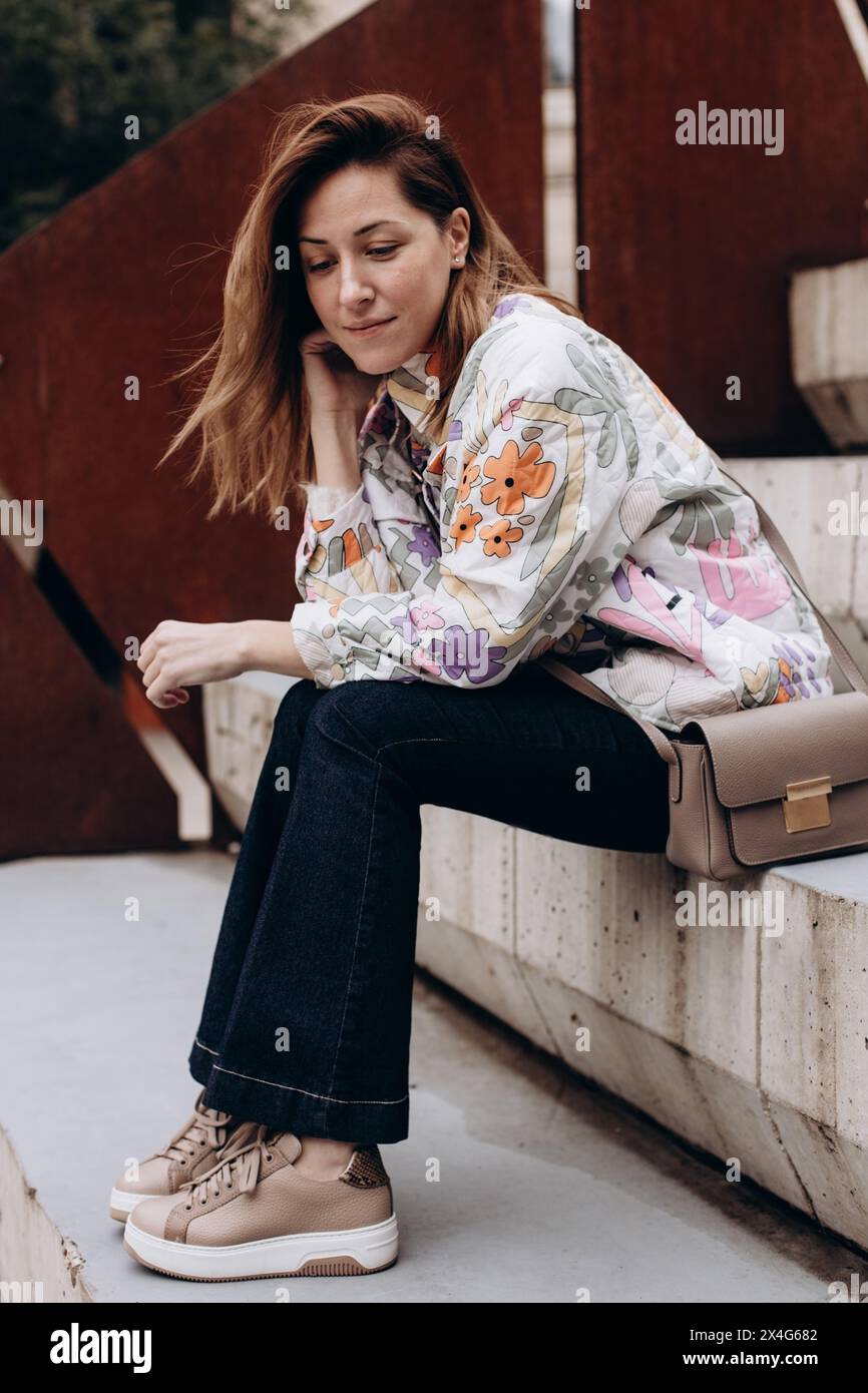 Portrait de femme en vêtements décontractés assis sur les marches Banque D'Images