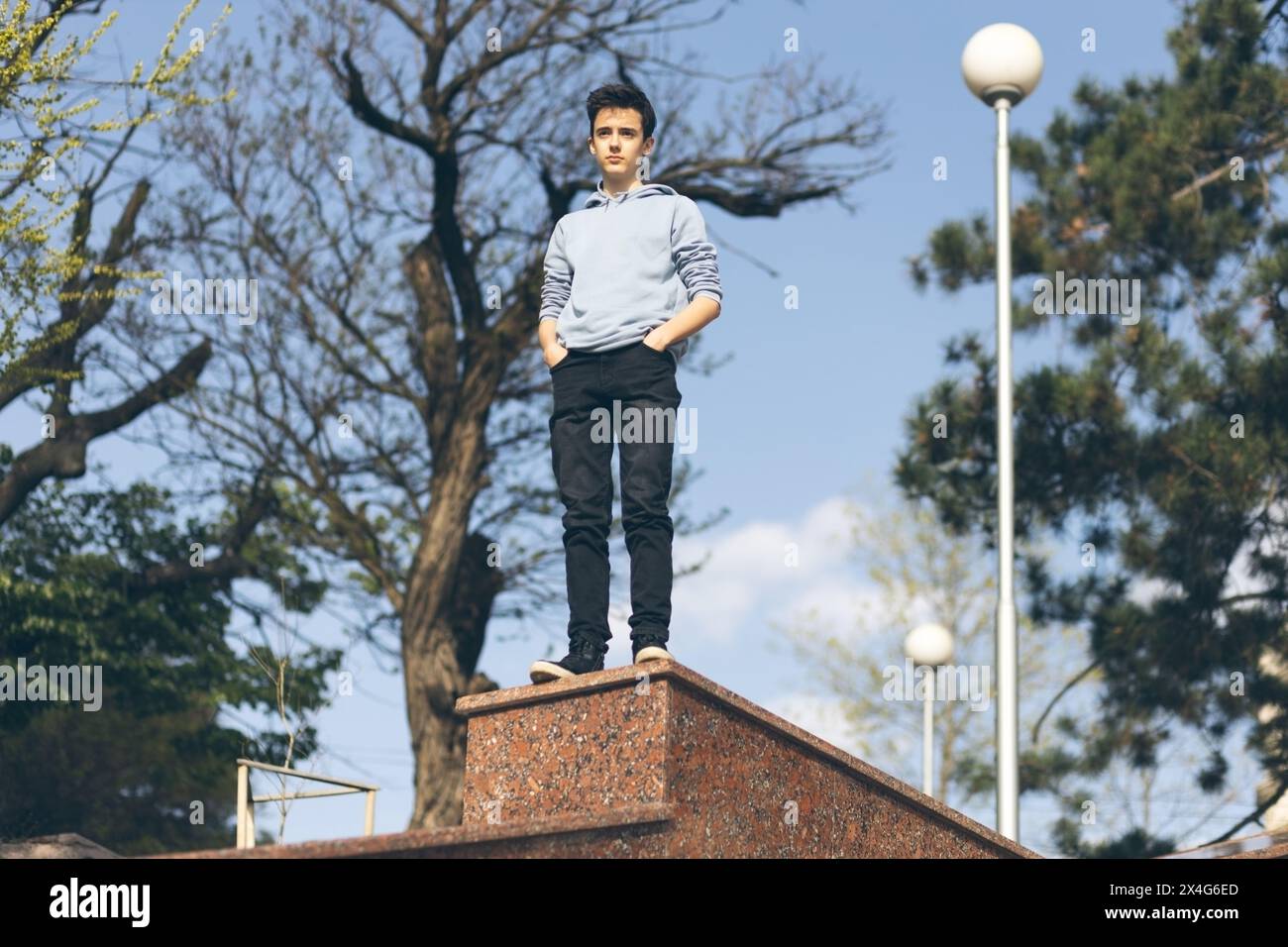 Portrait d'adolescent dans des vêtements décontractés à fond de ciel bleu Banque D'Images