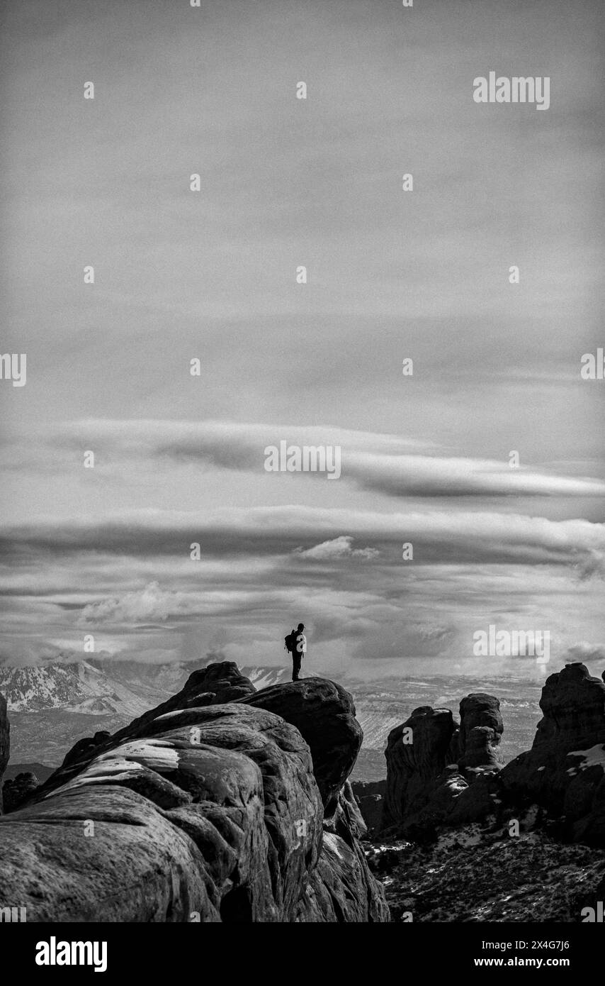 Randonneur se tient sur l'aileron de grès lors de la randonnée dans le parc national des Arches Banque D'Images