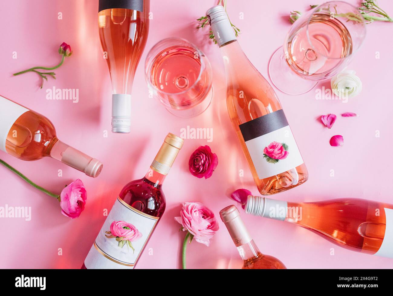 Bouteilles mélangées de vin rose, fleur de ranoncule et verre de vin sur Banque D'Images