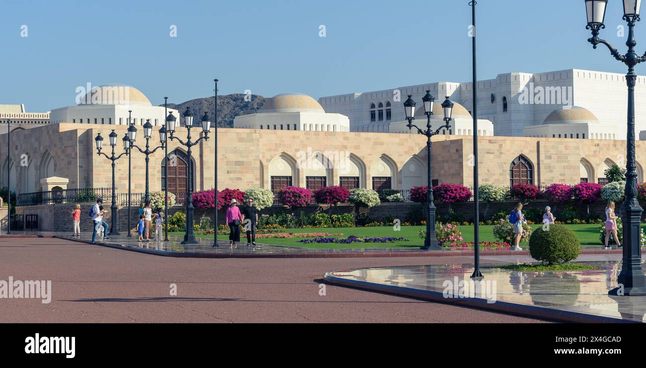 Muscat, Oman - 2 janvier 2024 : les visiteurs sont plongés dans le spectacle panoramique en traversant la vaste place du magnifique palais Al Alam. Banque D'Images