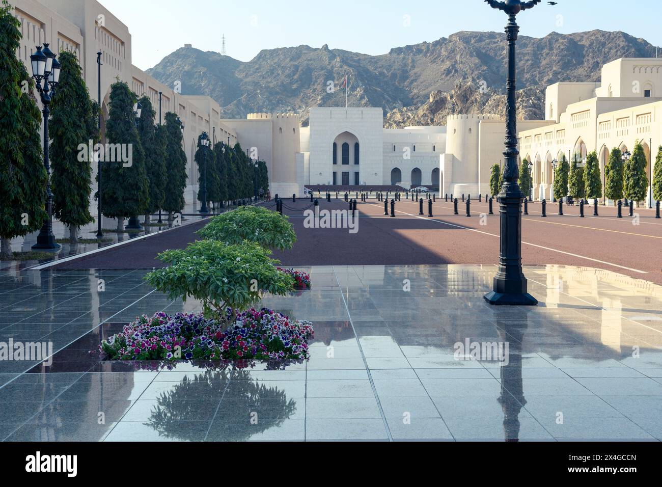 Muscat, Oman - 2 janvier 2024 : un groupe de touristes profite d'une visite guidée autour du majestueux palais Al Alam, entouré de magnifiques jardins et d'une moun Banque D'Images