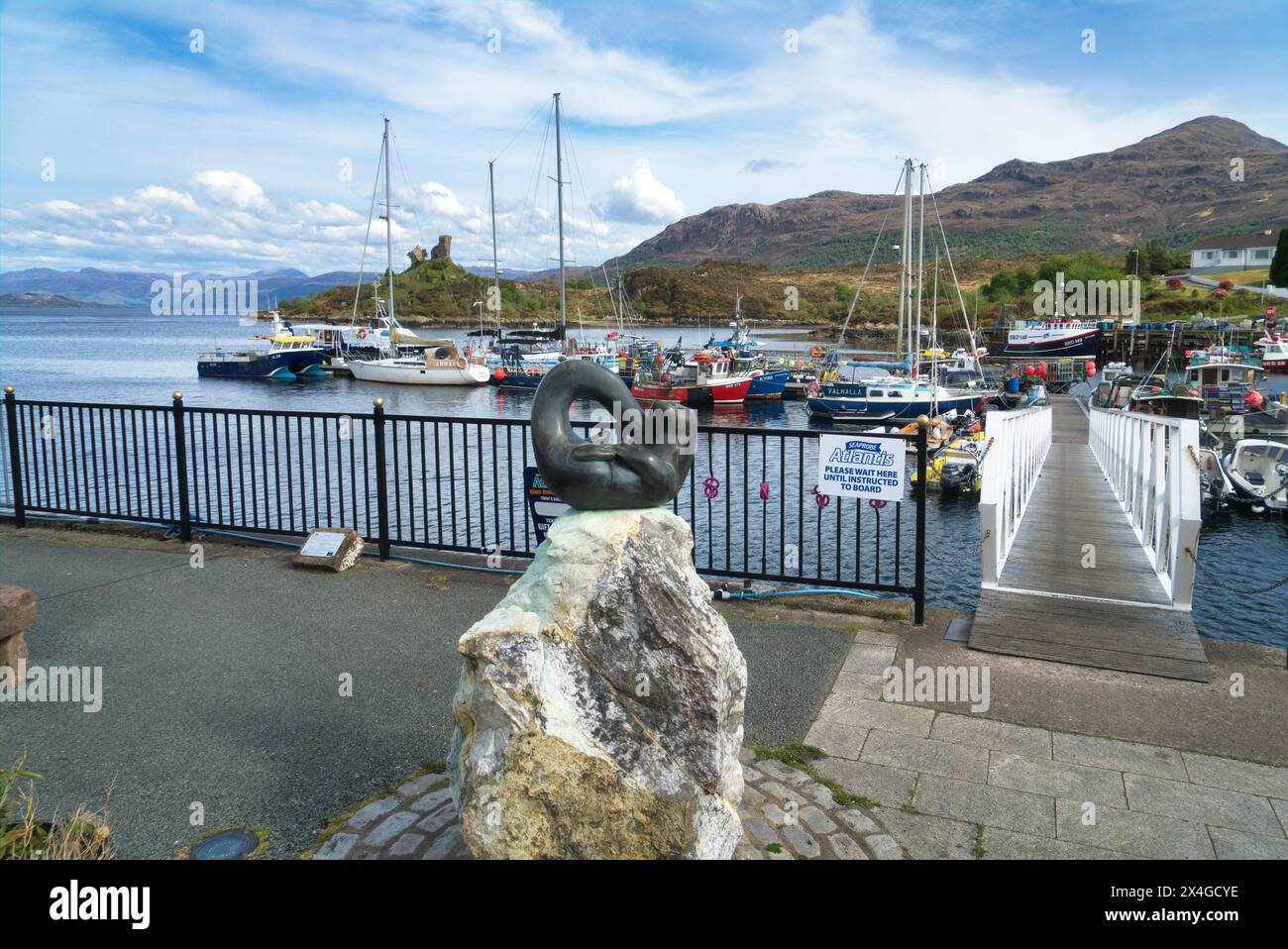 En regardant vers l'est vers le bas du Loch Alsh depuis le port de Kyleakin, île de Skye. Bateaux de pêche dans le port. Montrant le château de Moil en ruine. Skye, Highlands, Écosse, royaume-uni Banque D'Images