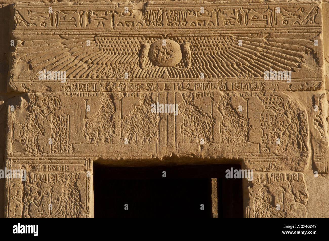 Égypte. Philae Temple, dédié à la déesse Isis. Érigé pendant les périodes ptolémaïque et romaine. Détail d'un relief avec représentation d'un disque solaire ailé au-dessus d'une porte du sanctuaire. Île d'Agilkia. Assouan. Banque D'Images