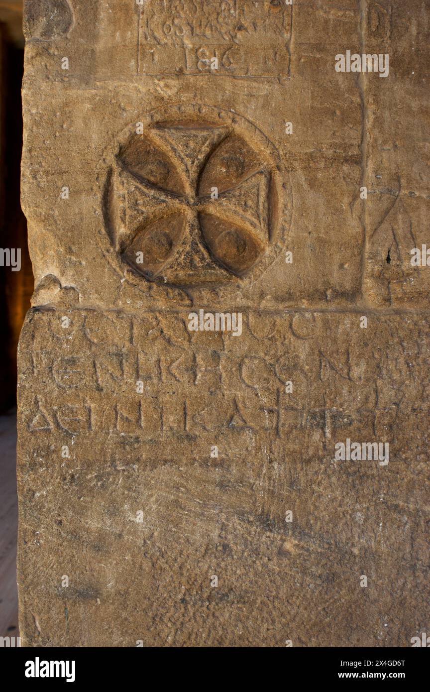 Égypte. Philae Temple, dédié à la déesse Isis. Érigé pendant les périodes ptolémaïque et romaine. Île d'Agilkia. Assouan. Croix chrétienne sculptée sur l'un des murs du sanctuaire. Dans les premiers jours du christianisme, il était courant de graver des symboles chrétiens sur les lieux de culte profane. Au vie siècle, l'empereur Justinien prohibe le culte à la déesse Isis, convertissant le complexe en une église chrétienne dédiée à Saint-Étienne, jusqu'au XIIe siècle, lorsque l'islam devient la religion majoritaire de la population égyptienne. Banque D'Images