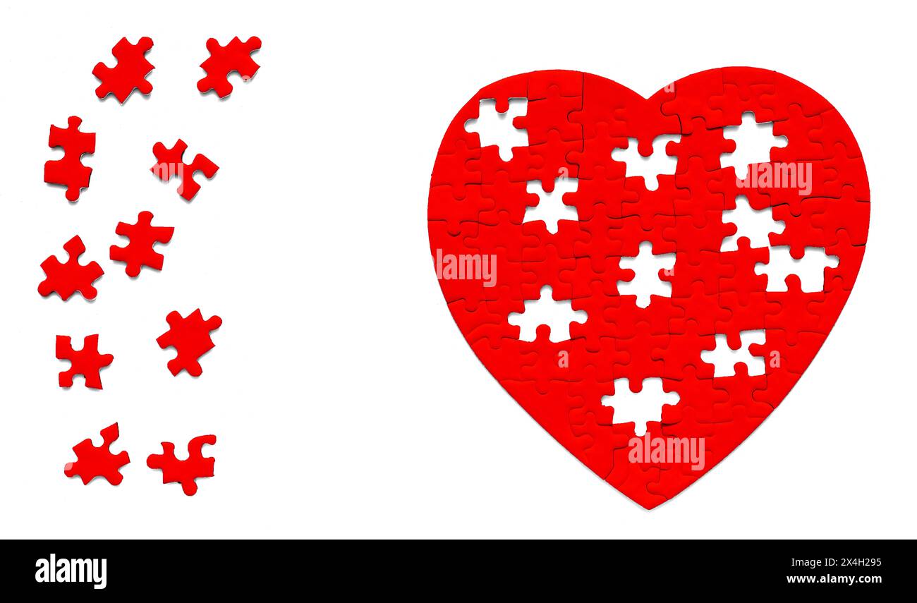 Vue rapprochée d'un puzzle rouge en forme de coeur et d'un groupe de pièces finales de puzzle à mettre en place isolé sur un fond blanc. Banque D'Images