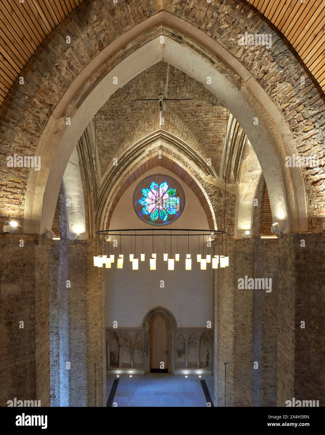 Élévation intérieure avec arcs gothiques et lustre. Abney Park Chapel, Londres, Royaume-Uni. Architecte : Kaner Olette Architects, 2023. Banque D'Images
