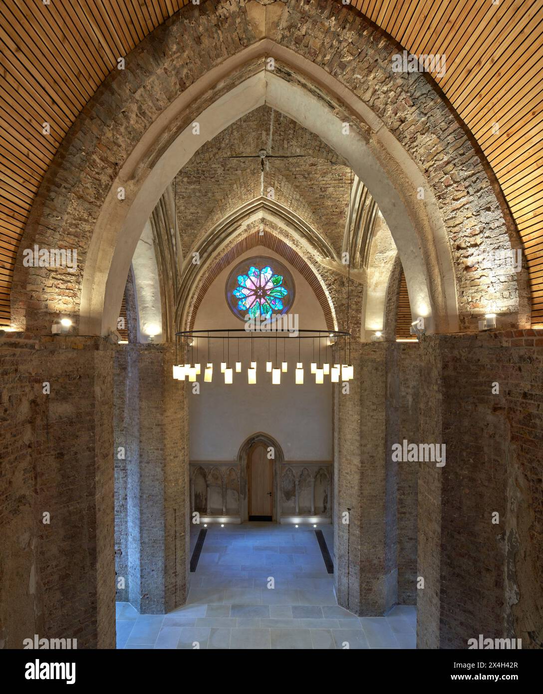 Élévation intérieure avec arcs gothiques et lustre. Abney Park Chapel, Londres, Royaume-Uni. Architecte : Kaner Olette Architects, 2023. Banque D'Images