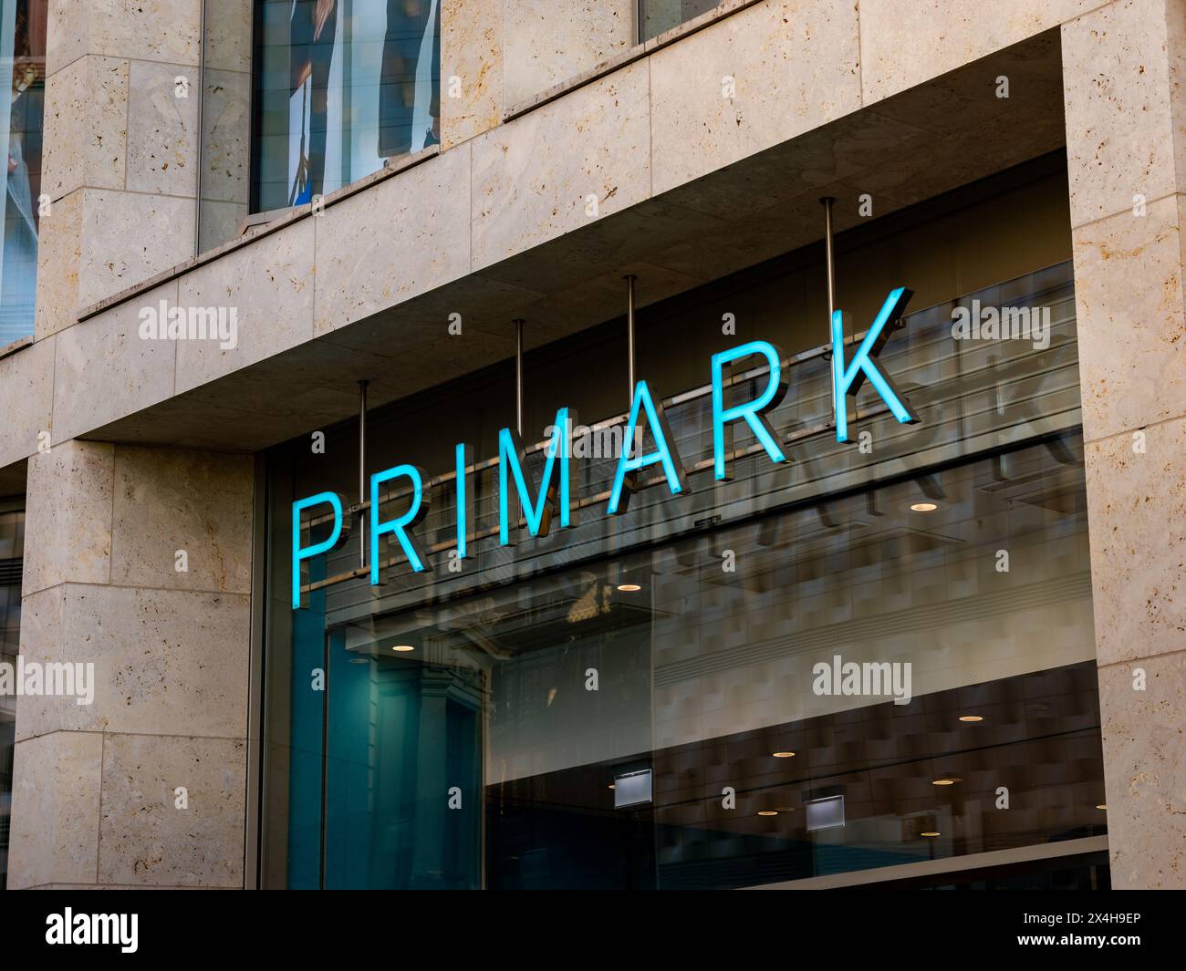 Logo PRIMARK signe de la chaîne de mode discount. Logotype illuminé au-dessus d'une entrée de bâtiment. Détaillant pour la mode rapide et employeur dans la ville. Banque D'Images
