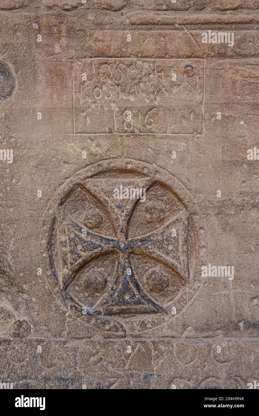 Une croix copte sculptée et des graffitis à l'intérieur du temple d'Isis au complexe du temple de Philae sur l'île d'Agilkia (un site du patrimoine mondial de l'UNESCO) en Égypte Banque D'Images