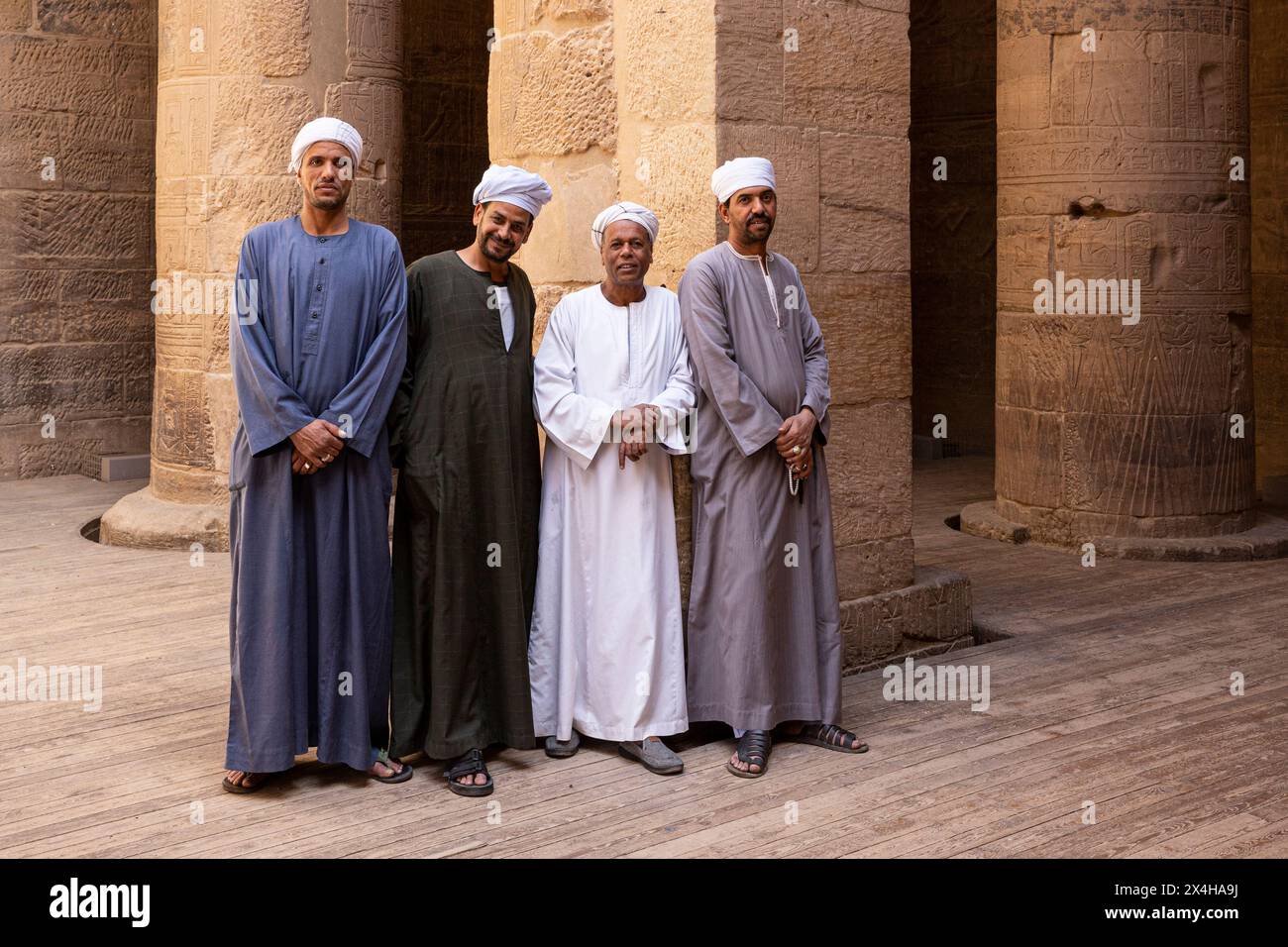 Hommes égyptiens en tenue traditionnelle au temple d'Isis à l'intérieur du complexe du temple de Philae (site du patrimoine mondial de l'UNESCO) sur l'île d'Agilkia, Egypte Banque D'Images