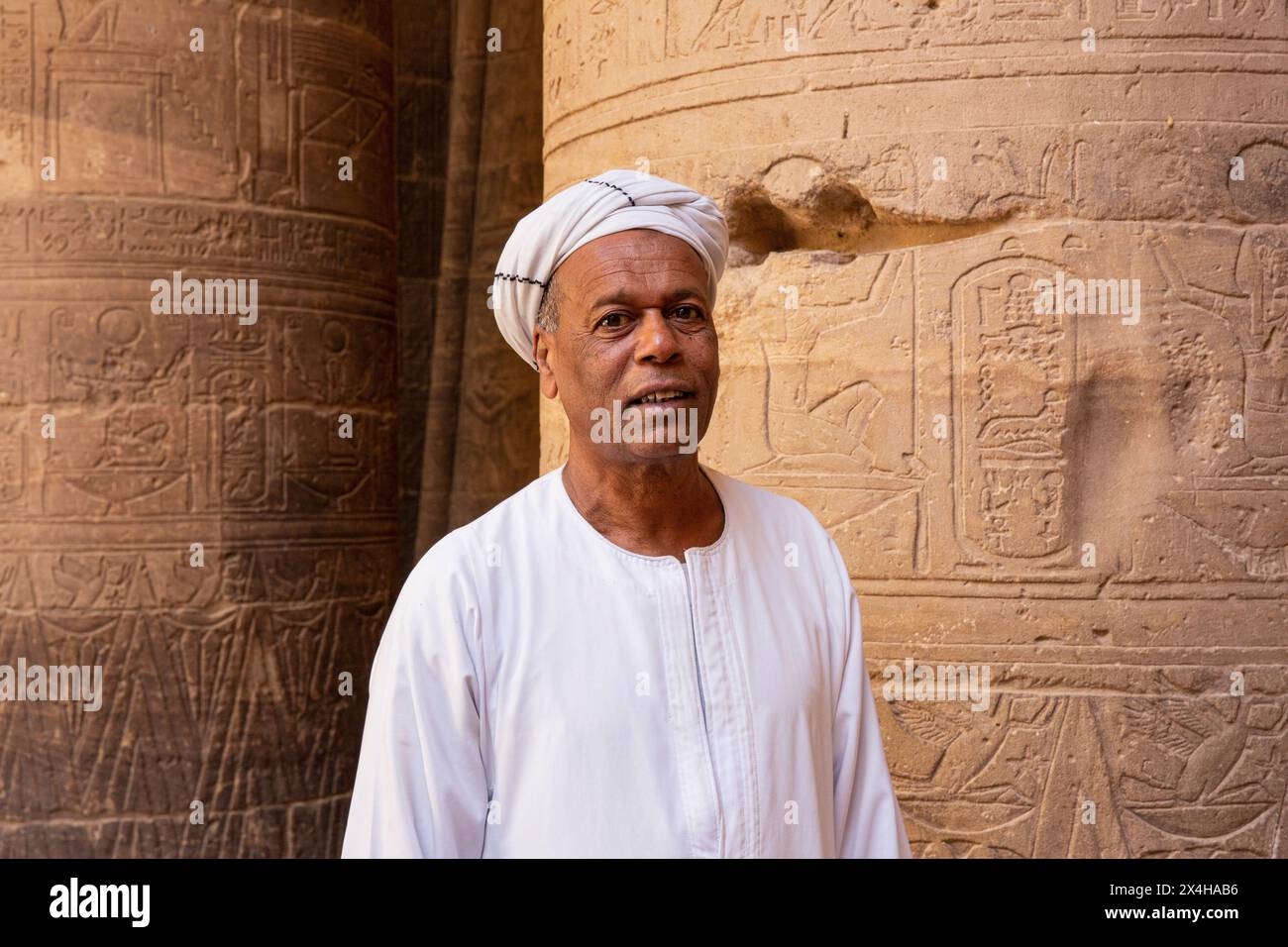 Un égyptien en tenue traditionnelle à l'intérieur du temple d'Isis au complexe du temple de Philae (un site du patrimoine mondial de l'UNESCO) sur l'île d'Agilkia, en Égypte Banque D'Images