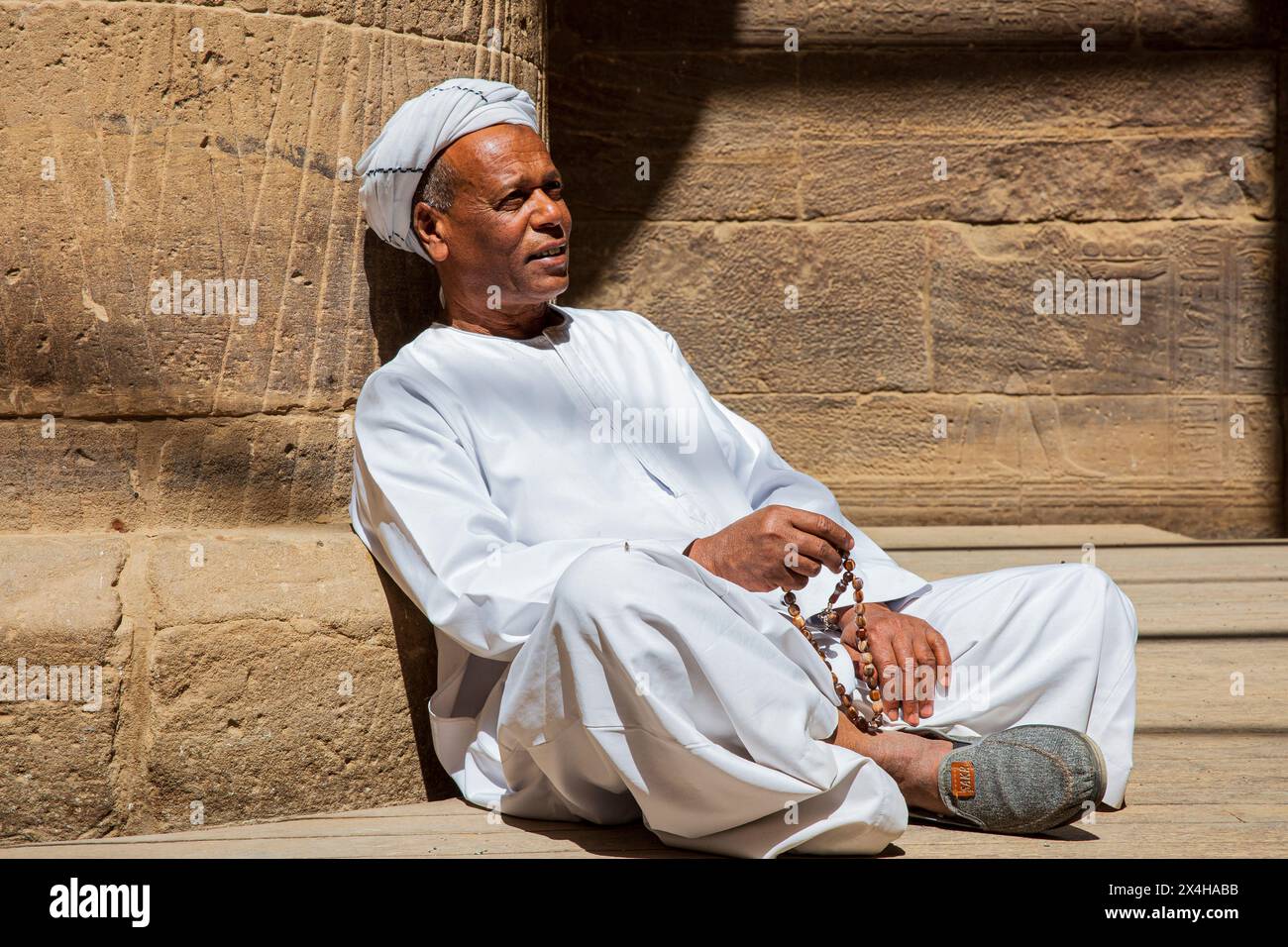 Un égyptien en tenue traditionnelle à l'intérieur du temple d'Isis au complexe du temple de Philae (un site du patrimoine mondial de l'UNESCO) sur l'île d'Agilkia, en Égypte Banque D'Images