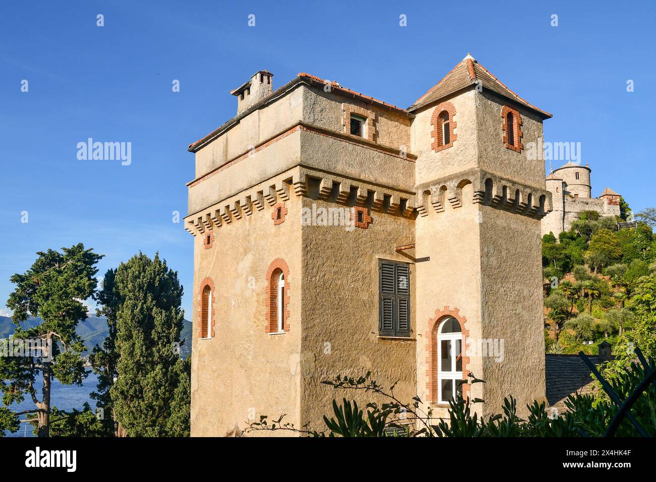 Villa la Torre, ou simplement la Tour de Portofino, avec le château brun en arrière-plan sur le promontoire, Portofino, Gênes, Ligurie, Italie Banque D'Images