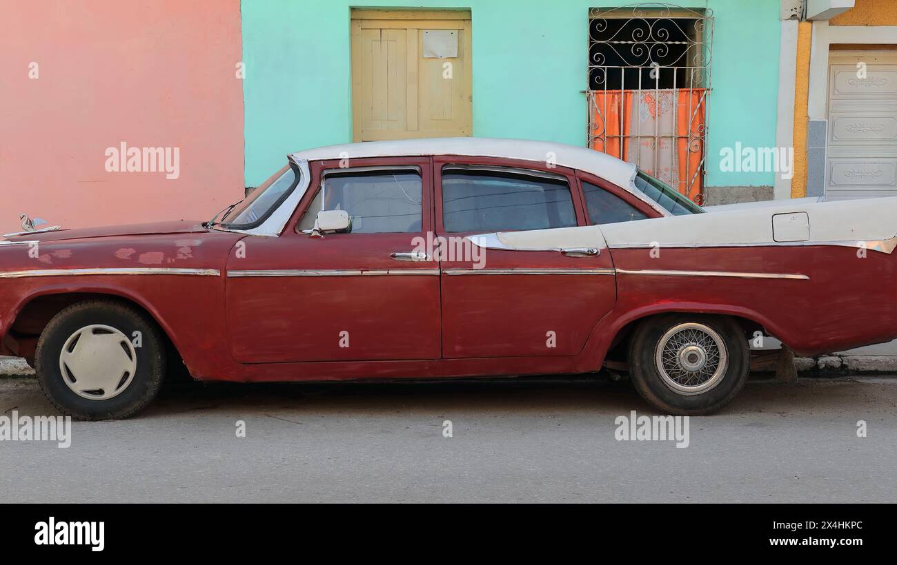 224 Red-maroon White almendron car -Dodge classic de 1958- stationné à côté des façades coloristes, rue dans le quartier Plaza Mayor Square. Trinidad-Cuba. Banque D'Images
