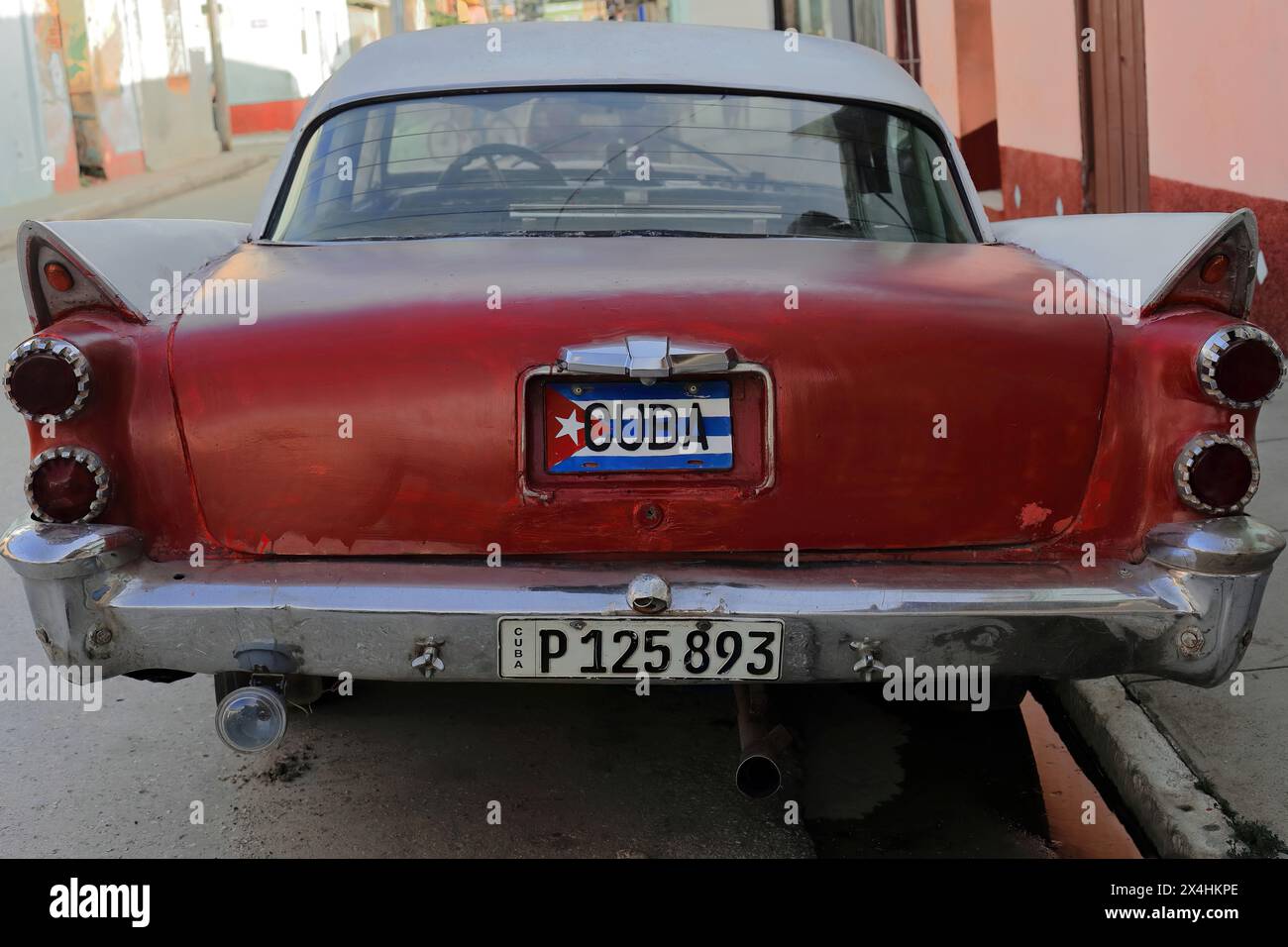 225 Red-maroon White almendron car -Dodge classic de 1958- arrêt parmi les maisons de l'époque coloniale, rue dans le quartier Plaza Mayor Square. Trinidad-Cuba. Banque D'Images