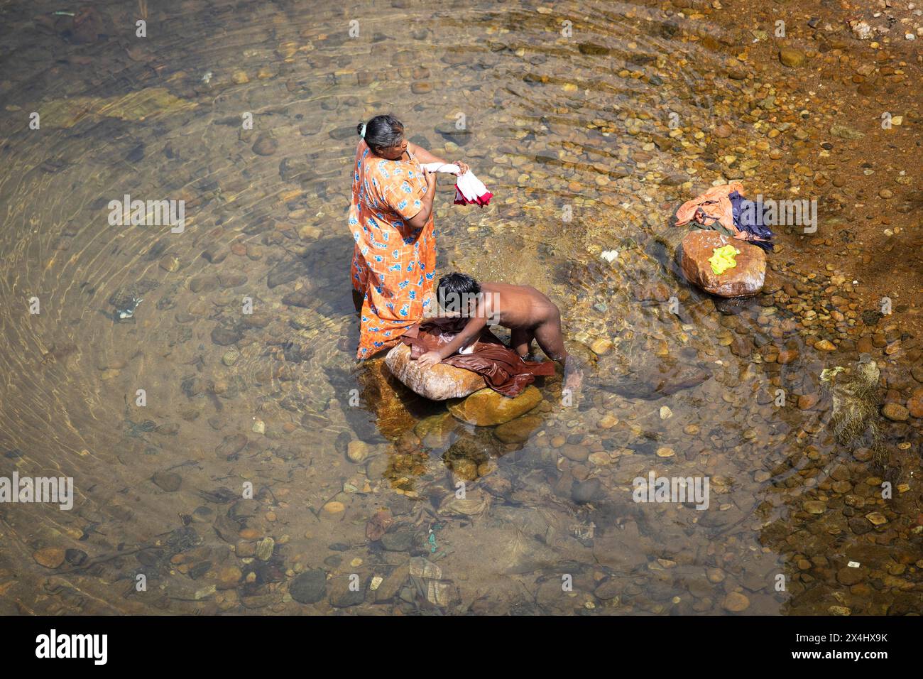 Femme indienne et son fils lavant des vêtements dans la rivière Periyar, Mundakayam, Kerala, Inde Banque D'Images