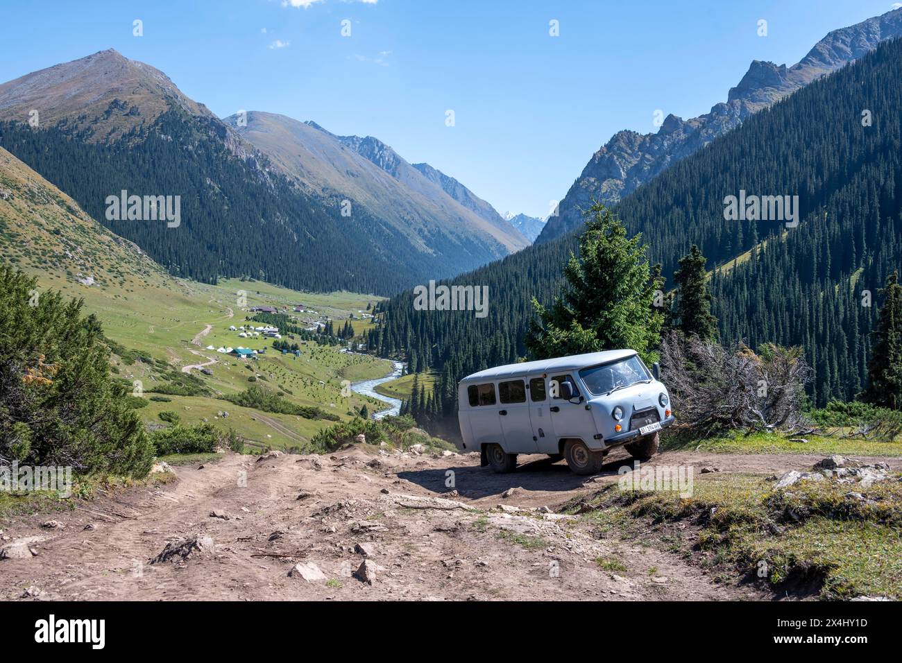 UAZ Buchanka, véhicule tout-terrain russe sur piste 4x4, vallée de montagne verte avec village Altyn Arashan, montagnes Tien Shan, Kirghizistan Banque D'Images