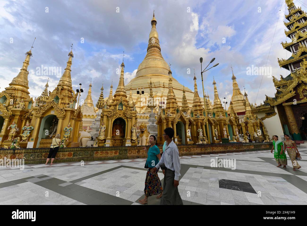 Pèlerins à la pagode Shwedagon, Yangon, Myanmar, Asie, stupa doré impressionnant et architecture ornementée de la pagode Shwedagon sous le ciel bleu avec Banque D'Images