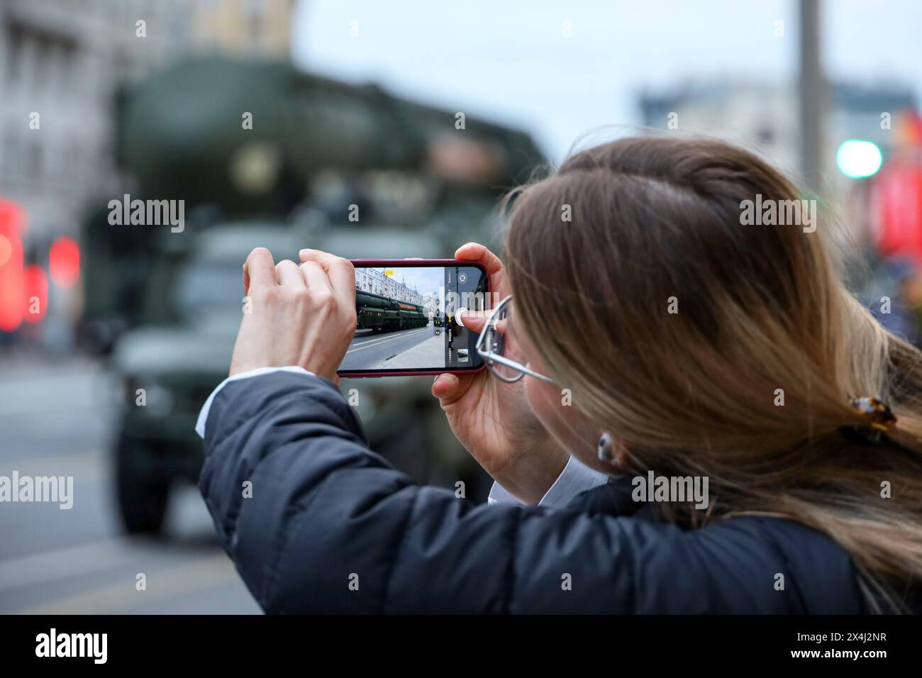 Femme photographie sur l'appareil photo de smartphone système de missiles stratégiques russe 'Yars' dans la rue de la ville avant le défilé du jour de la victoire Banque D'Images
