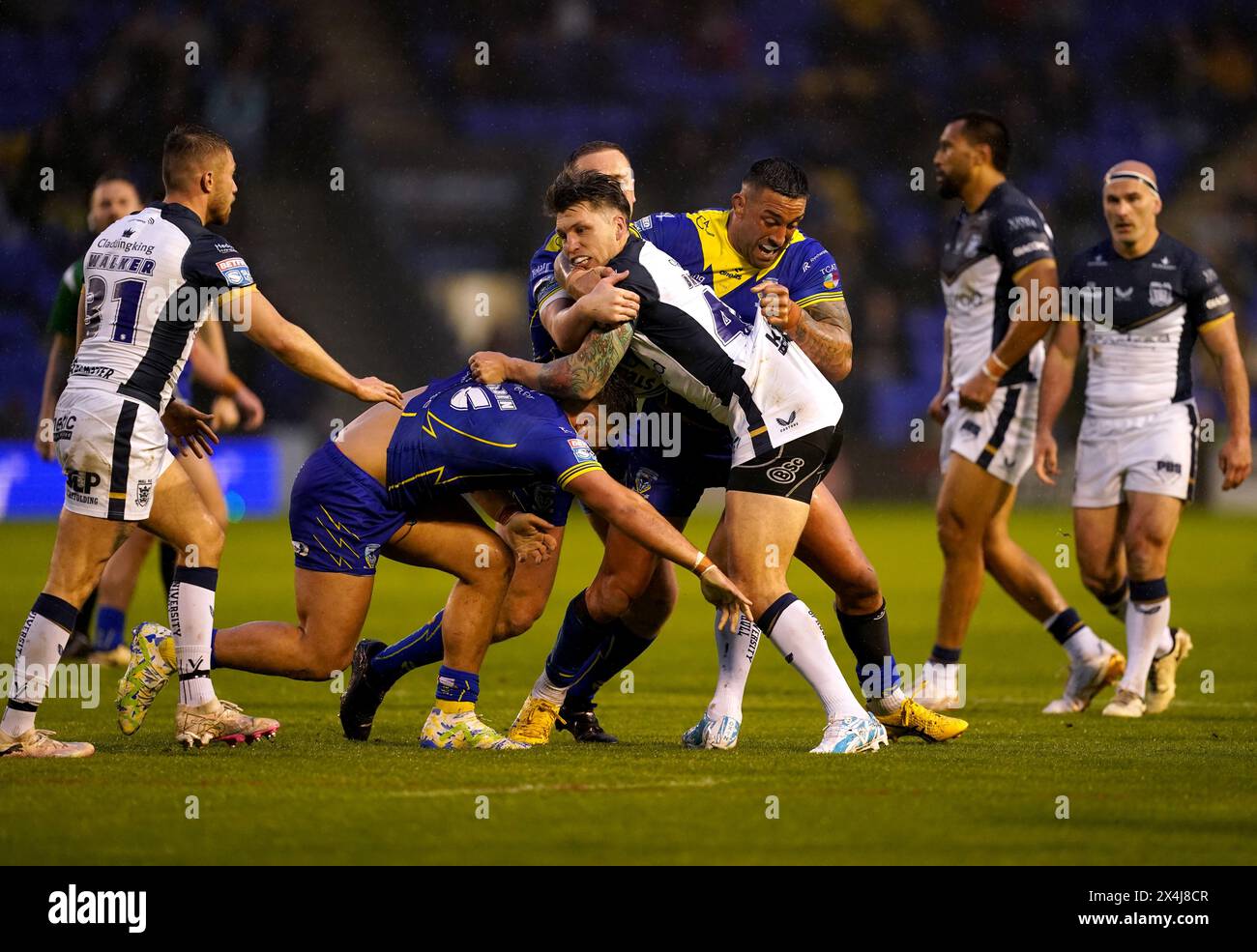 Tom Briscoe du Hull FC (au centre) est attaqué par Paul Vaughan et Joe Philbin des Warrington Wolves lors du match de Super League de Betfred au stade Halliwell Jones de Warrington. Date de la photo : vendredi 3 mai 2024. Banque D'Images