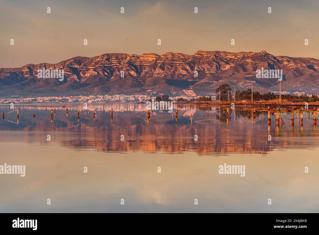 Lever de soleil dans la baie d'Alfacs dans le delta de l'Èbre, avec la chaîne de montagnes Montsià en arrière-plan (Tarragone, Catalogne, Espagne) Banque D'Images