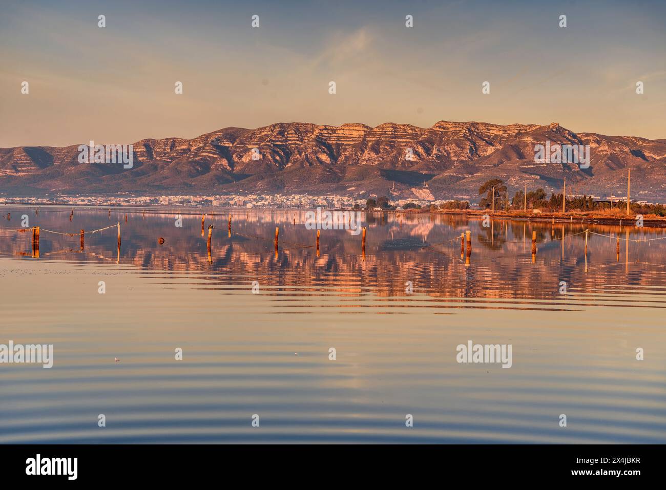 Lever de soleil dans la baie d'Alfacs dans le delta de l'Èbre, avec la chaîne de montagnes Montsià en arrière-plan (Tarragone, Catalogne, Espagne) Banque D'Images