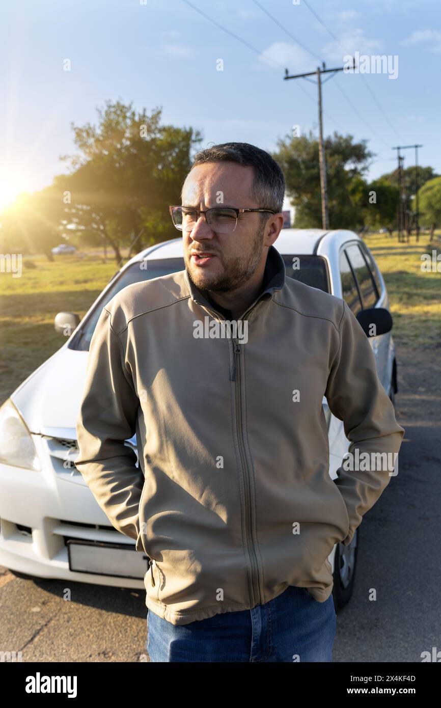 homme blanc avec des lunettes devant la voiture sur le bord de la route, en attente d'assistance, en afrique du sud Banque D'Images