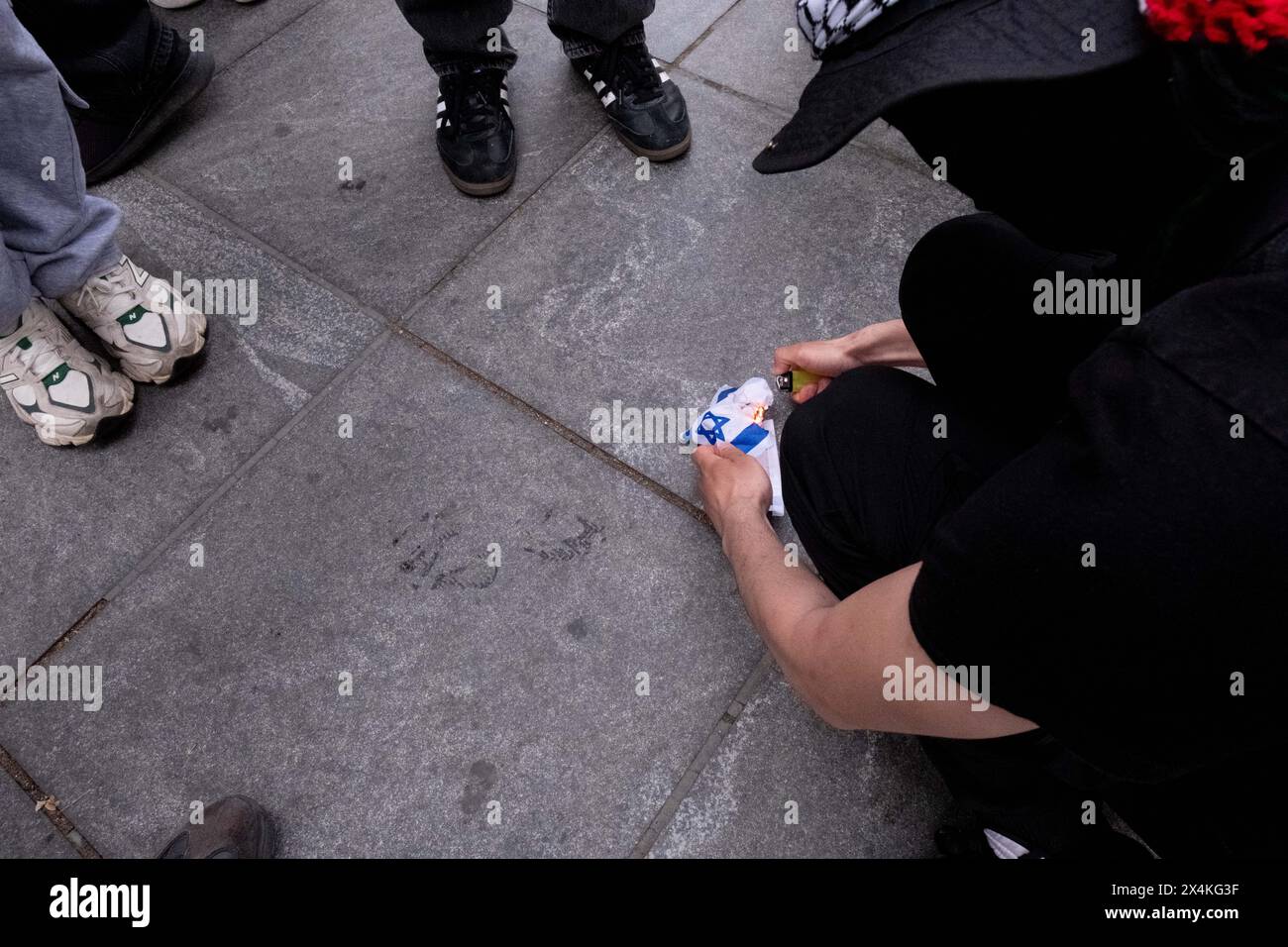 New York, États-Unis. 03 mai 2024. Les manifestants brûlent un petit drapeau israélien pendant la manifestation. Les groupes étudiants pro-palestiniens continuent de manifester à New York. Après que le NYPD eut nettoyé les campements à la fois à la NYU et à la New School tôt vendredi matin, les étudiants se sont rassemblés au Paulson Center de NYU, ont marché vers la New School, puis vers le Washington Square Park. La marche a été organisée par Shut It Down for Palestine, une coalition d'organisations exigeant un cessez-le-feu et la réduction de l'aide à Israël. Crédit : SOPA images Limited/Alamy Live News Banque D'Images