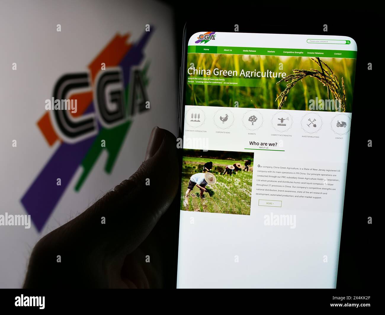 Personne tenant le téléphone portable avec la page Web de la société chinoise China Green Agriculture Inc (CGA) devant le logo. Concentrez-vous sur le centre de l'écran du téléphone. Banque D'Images