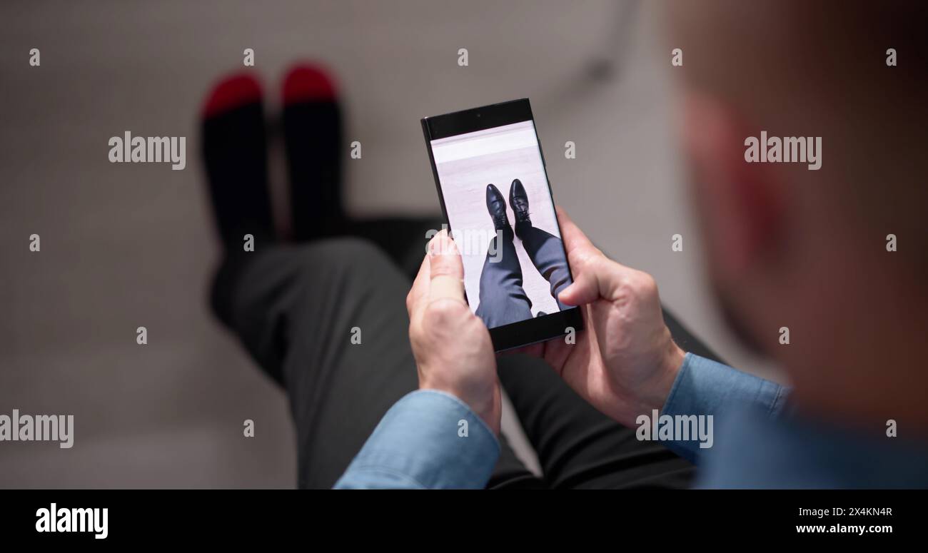 Homme essayant des baskets virtuelles dans Shop ou Store AR App Banque D'Images Homme essayant des baskets virtuelles dans Shop ou Store AR App Banque D'Images
