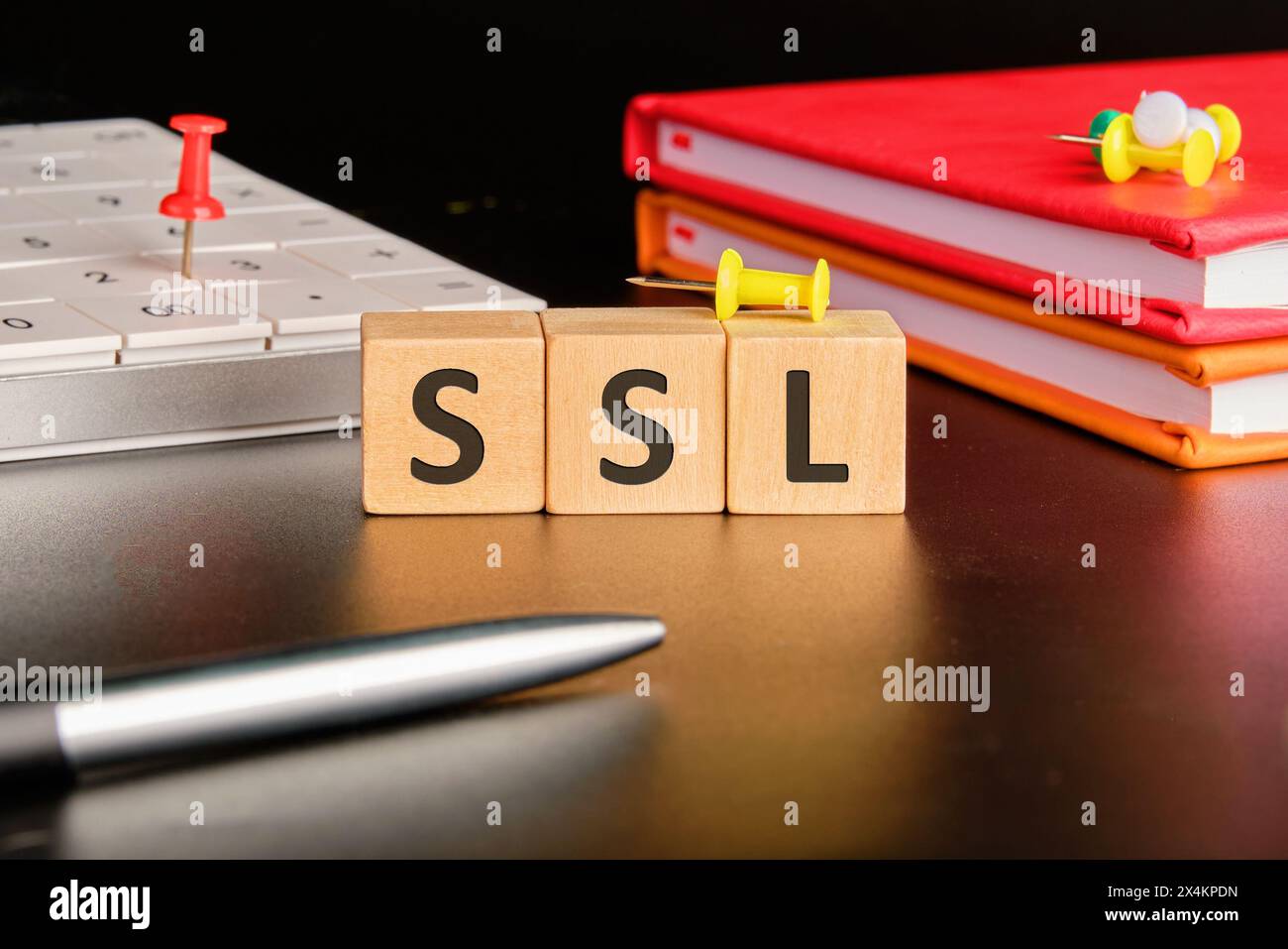 SSL - Secure Sockets Layer écrit sur des cubes en bois sur un fond noir dans une composition avec une calculatrice, des cahiers et un stylo Banque D'Images