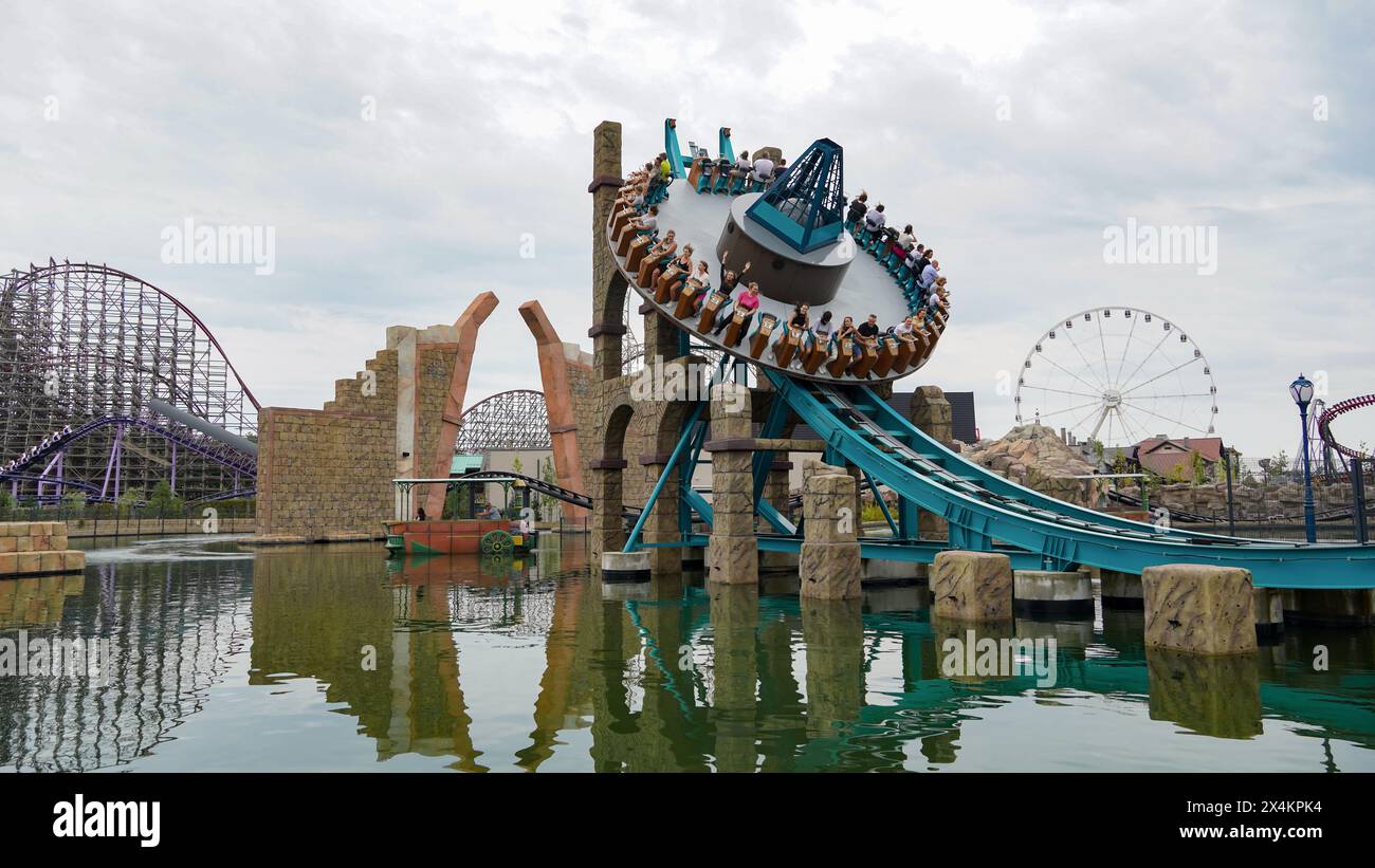 Les gens s'amusent sur le 'Disk'o Coaster' 'Tidal wave Twister' au parc d'attractions 'Energylandia' Banque D'Images