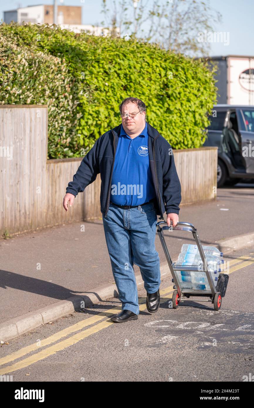 Un homme utilise un trolleypour obtenir des bouteilles d'eau n'ayant pas d'eau taop à la maison. . Environ 31 000 propriétés à St Leonards et dans certaines parties de Hastings restent sans eau après que Southern Water ait déclaré qu'une rupture de la principale avait perturbé les approvisionnements. On pense qu'il faudra tout le week-end pour réparer le tuyau d'alimentation électrique éclaté. Prog Leonards, East Sussex. Crédit : Reppans/Alamy Live News Banque D'Images