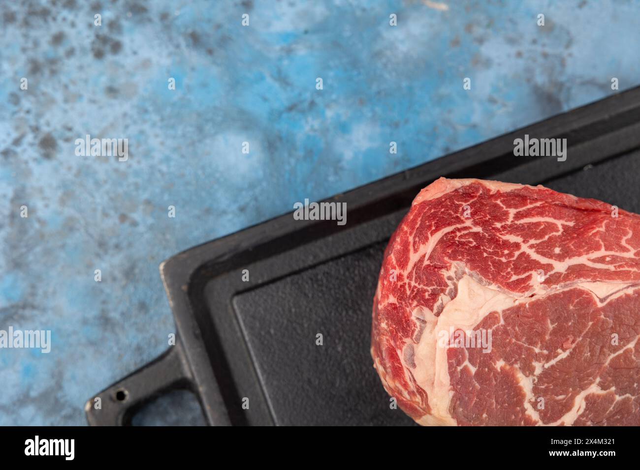 steak de bœuf cru frais sur fond bleu, vue de dessus, copier spase Banque D'Images