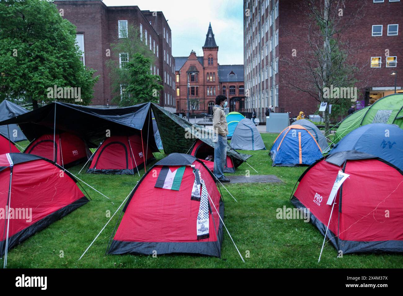 Un manifestant masqué se tient parmi les tentes du camp de résistance grandissant. Étudiants et supporters occupent Brunswick Park à l'Université de Manchester. Les manifestants exigent que l’Université cesse d’armer Israël et mette fin à leur complicité dans le génocide. Ils insistent pour que l’Université mette fin à son partenariat avec le fabricant d’armes BAE Systems, mette fin à ses liens avec tel Aviv et les universités hébraïques en Israël, et adopte une politique garantissant que toute la recherche est éthique et ne contribue pas au commerce des armes. Les manifestants sont déterminés à rester en occupation jusqu'à ce que leurs revendications soient satisfaites (photo de Martin Pope/SOPA IM Banque D'Images