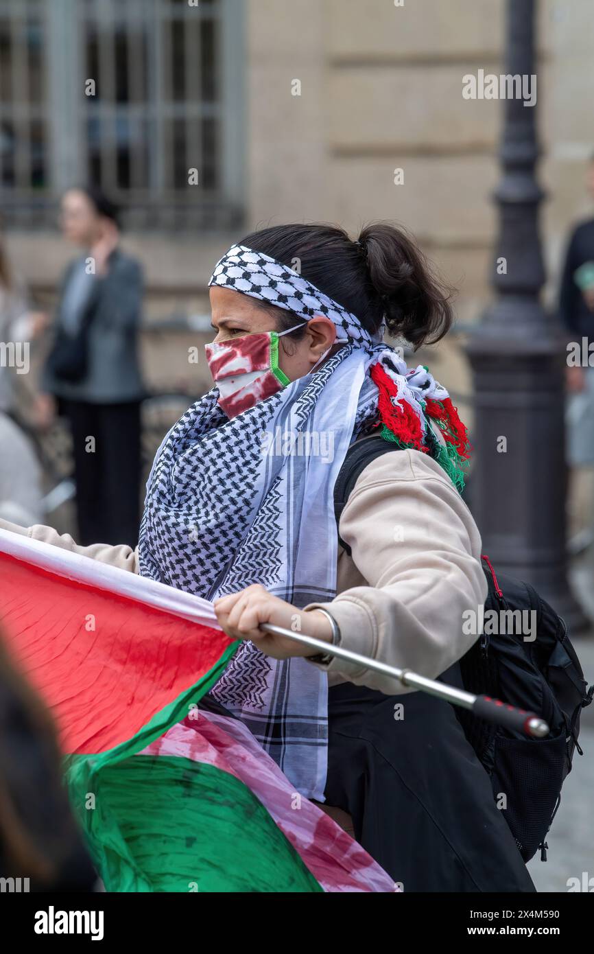 Une femme porte une écharpe en keffiyeh et un masque taché de sang (peinture) lors d'une manifestation pro-Palestine menée par des lycéens devant le Panthéon à Paris. En signe de solidarité avec la Palestine, des lycéens et des étudiants français se sont rassemblés devant le Panthéon à Paris, dénonçant la violence continue à Gaza et appelant à la fin de ce qu’ils ont décrit comme un génocide. La manifestation pacifique pro-palestinienne a été accueillie par la présence de la police anti-émeute, qui a également géré une contre-manifestation pro-israélienne à proximité. Drapeaux, signes et chants remplissaient l'air alors que les deux côtés exprimaient leurs perspectives Banque D'Images