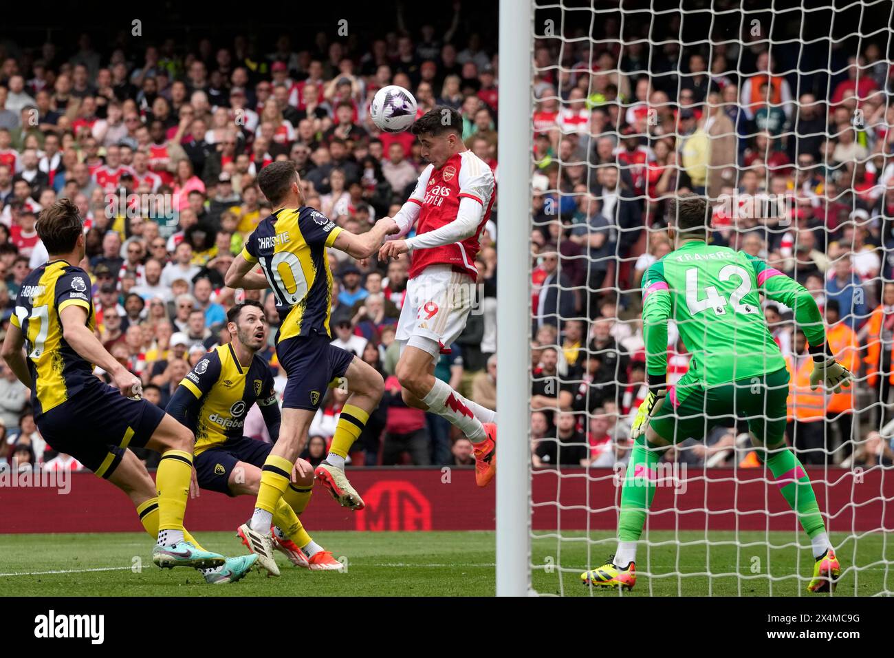 Arsenal's Kai Havertz, centre, heads the ball ahead of Bournemouth's Ryan Christie during the English Premier League soccer match between Arsenal and Bournemouth at Emirates Stadium in London, England, Saturday, May 4, 2024. (AP Photo/Frank Augstein) Banque D'Images