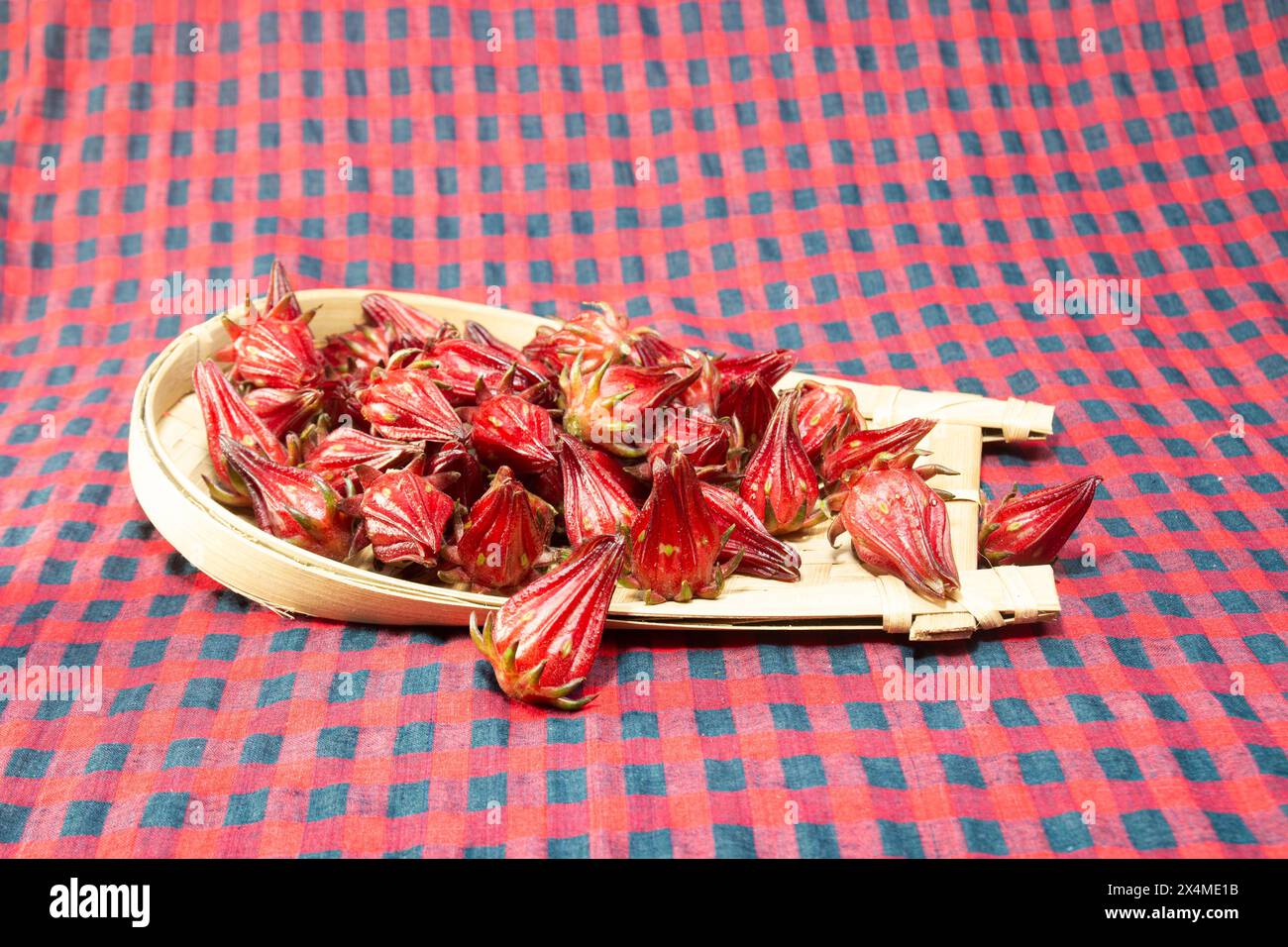 La fleur de Roselle est une herbe au goût aigre et est couramment utilisée pour faire du thé. Hibiscus sabdariffa. Sur un plateau en bambou. Banque D'Images