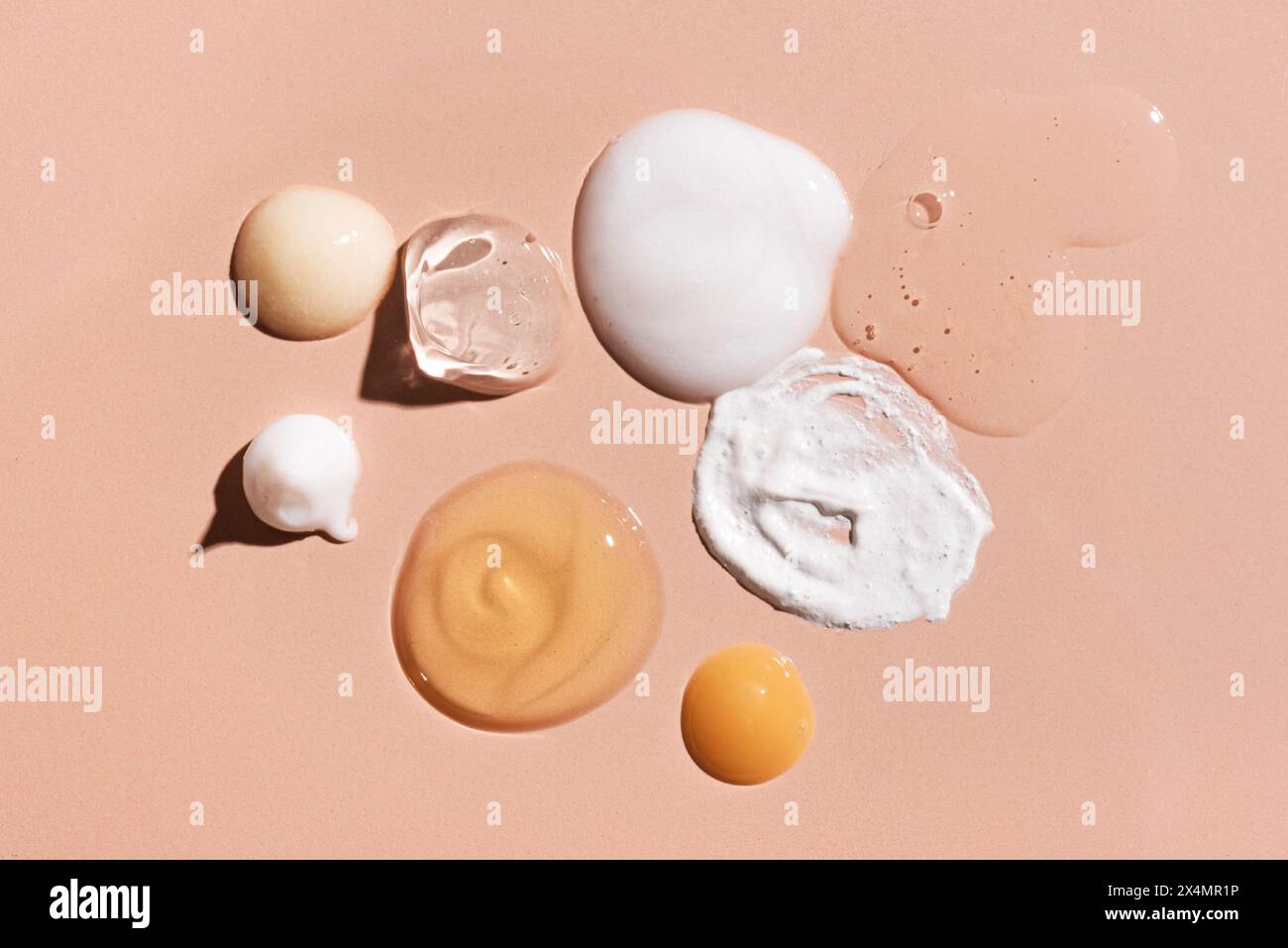 Ensemble de cosmétique échantillon sur fond rose beige. Produits de beauté pour les soins du visage et du corps : hydratant, essence de sérum, mousse nettoyante, tonique, reti Banque D'Images