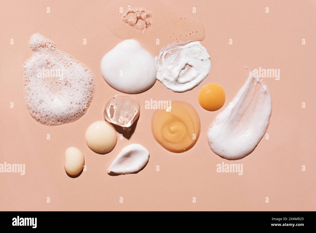 Ensemble de cosmétique échantillon sur fond rose beige. Produits de beauté pour les soins du visage et du corps : hydratant, essence de sérum, mousse nettoyante, tonique, argile Banque D'Images